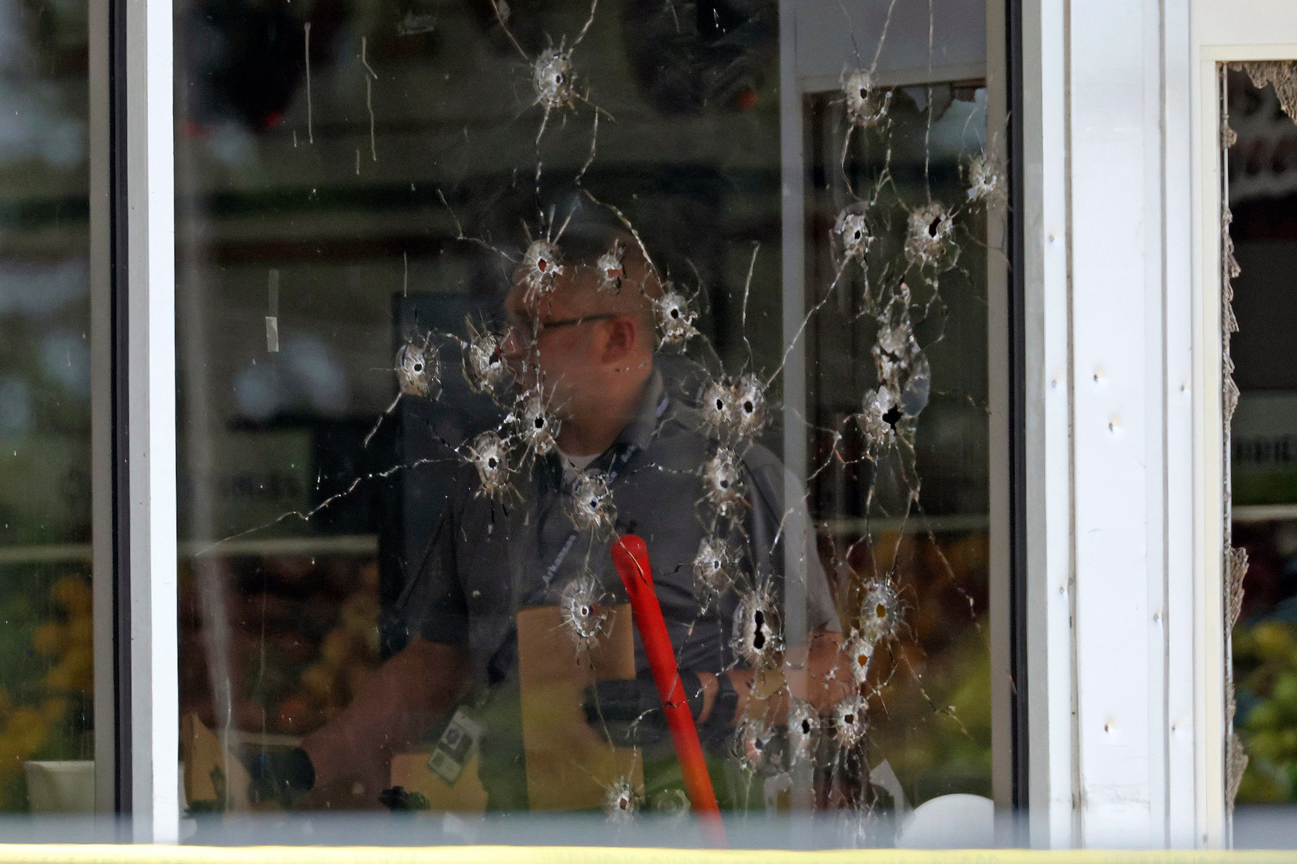 Las imágenes de los reporteros que se encontraban en el lugar de los hechos mostraban un montón de agujeros de bala en el escaparate de la tienda y casquillos de bala esparcidos por el estacionamiento.