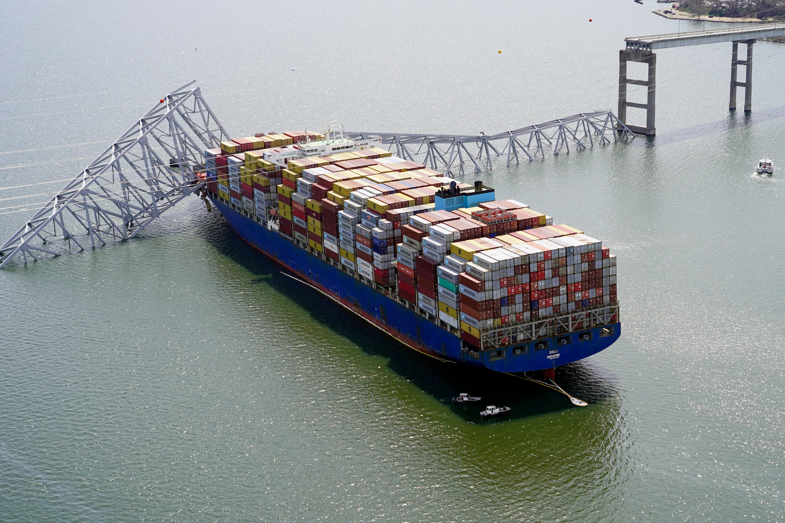 En esta imagen, distribuida por la Guardia Nacional de Maryland, el carguero Dalí, varado bajo un tramo derrumbado puente Francis Scott Key tras chocar contra la estructura, el 26 de marzo de 2024, en Baltimore.