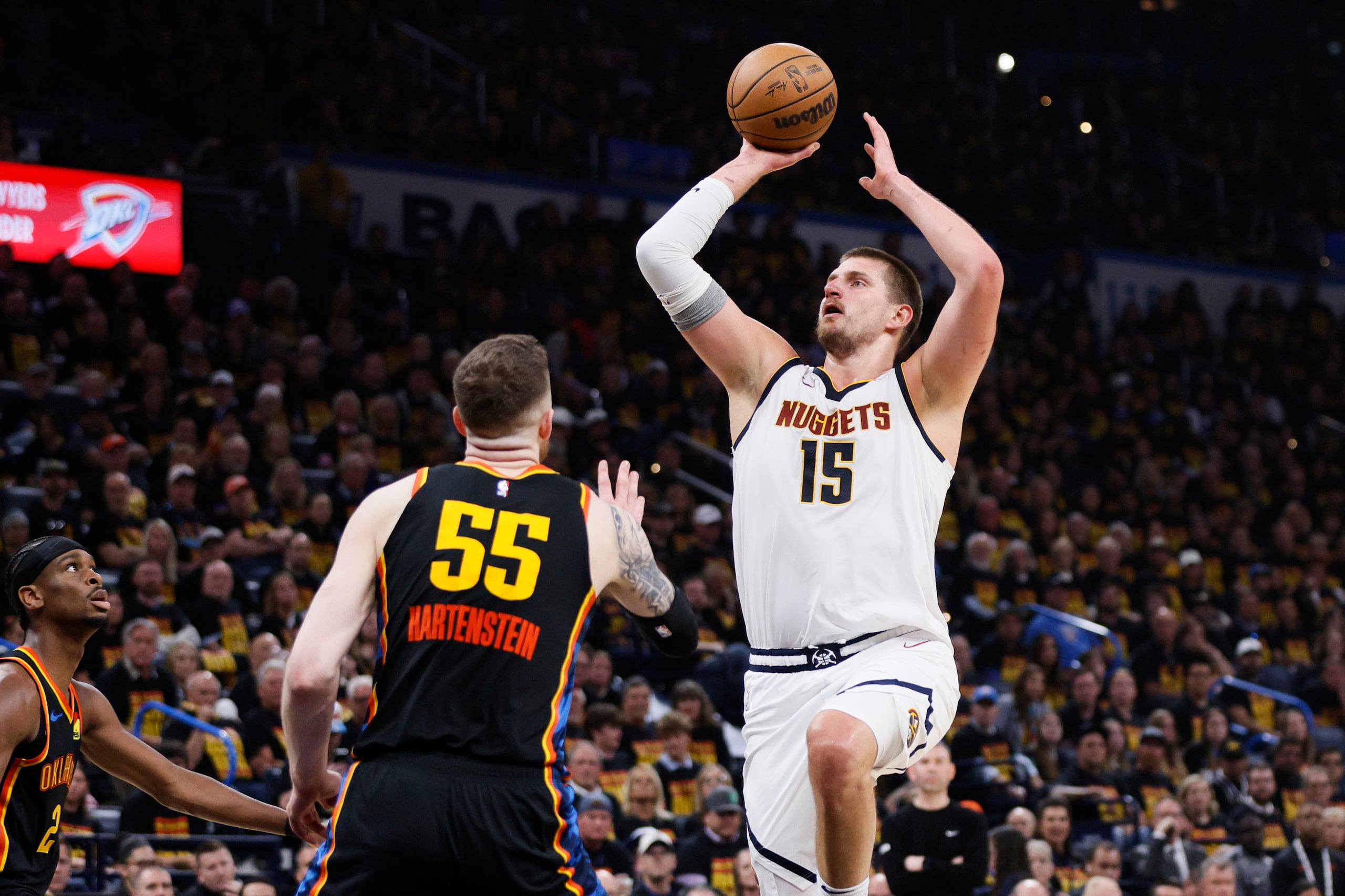 Nikola Jokic, de los Nuggets de Denver, lanza al canasto ante la defensa del Thunder de Oklahoma City,