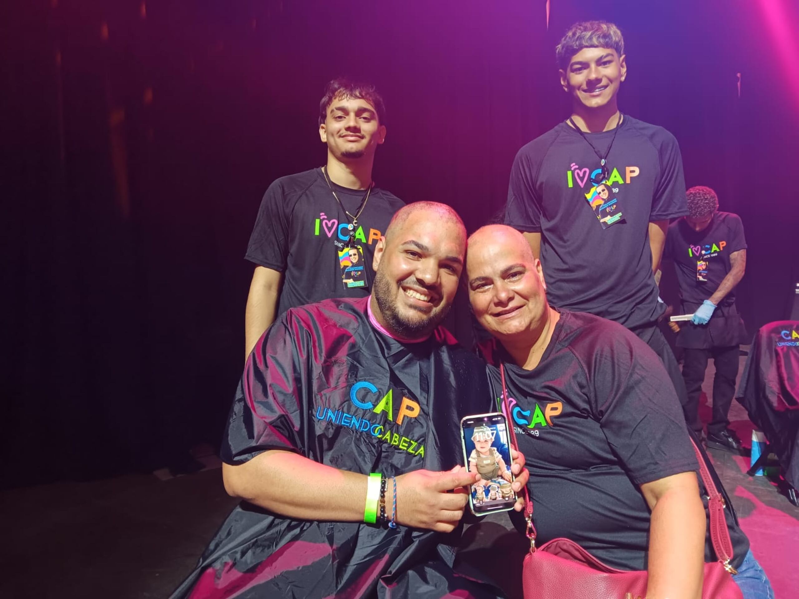 Daniel Mercado se rapó el cabello por primera vez en solidaridad con su madre (derecha) y su sobrino (celular), ambos pacientes de cáncer. Los barberos Christian González y Kenneth Gracia lo ayudaron en el proceso.
