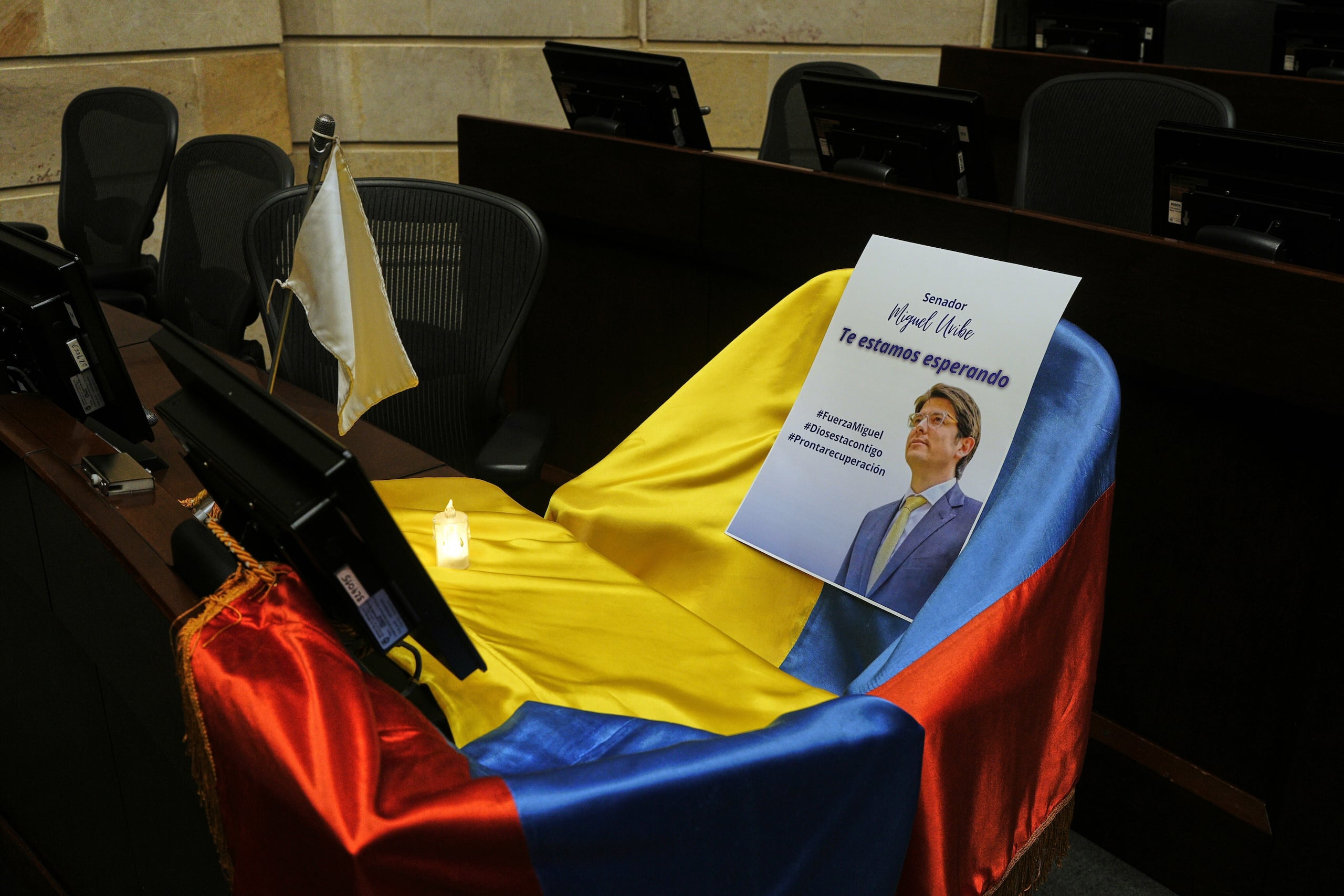 Un folleto que muestra al senador colombiano Miguel Uribe Turbay está sobre una bandera nacional de Colombia que cubre su asiento en la cámara del Congreso en Bogotá, Colombia, el 9 de junio de 2025.