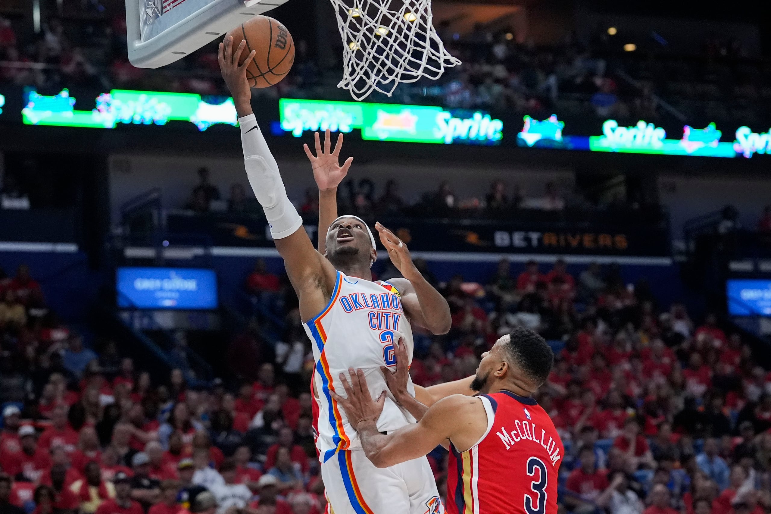 Shai Gilgeous-Alexander, del Thunder de Oklahoma City, ataca el canasto frente a CJ McCollum, de los Pelicans de Nueva Orleans.