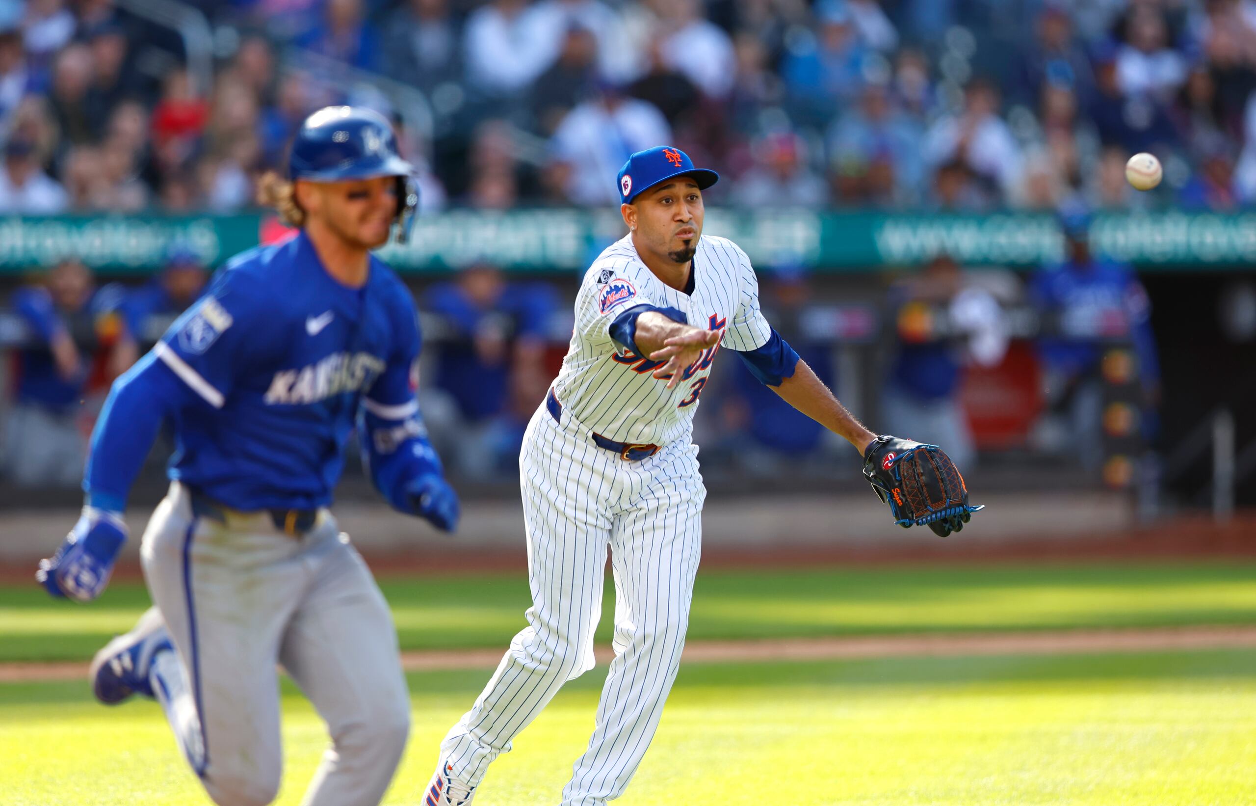 Edwin Díaz lanza la bola hacia la primera base para sacar de out a Bobby Witt Jr.