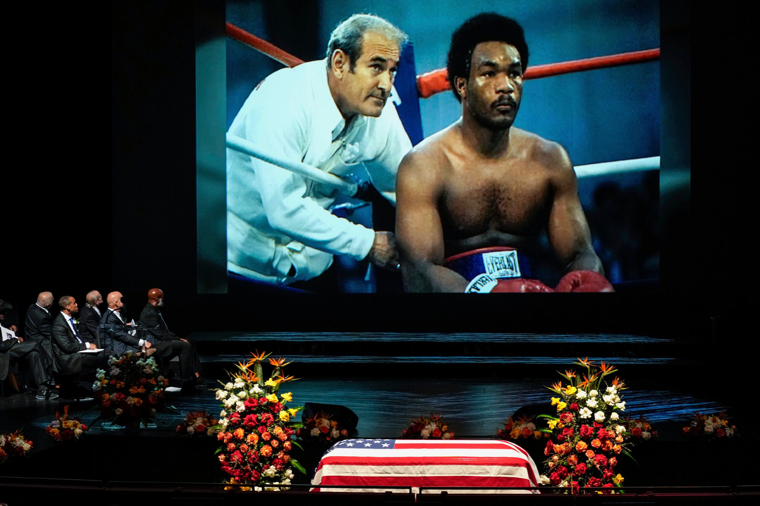 Una foto de George Foreman sentado en la esquina del cuadrilátero se muestra durante un video de homenaje al boxeador campeón olímpico y mundial y ministro Foreman durante su servicio conmemorativo en el Wortham Theater Center de Houston, el lunes 14 de abril de 2025. (Brett Coomer/Houston Chronicle vía AP)