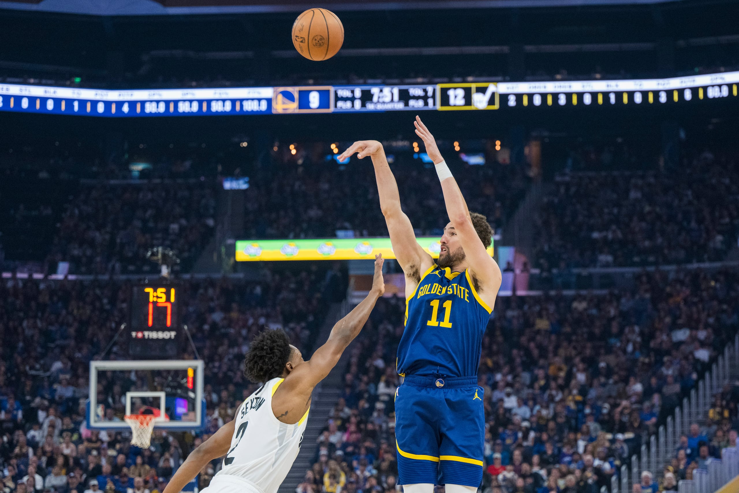 Klay Thompson (11), de los Warriors de Golden State, dispara un triple sobre Collin Sexton (2), del Jazz de Utah, durante la primera mitad del juego de baloncesto de la NBA, el domingo 7 de abril de 2024, en San Francisco. (AP Foto/Nic Coury)