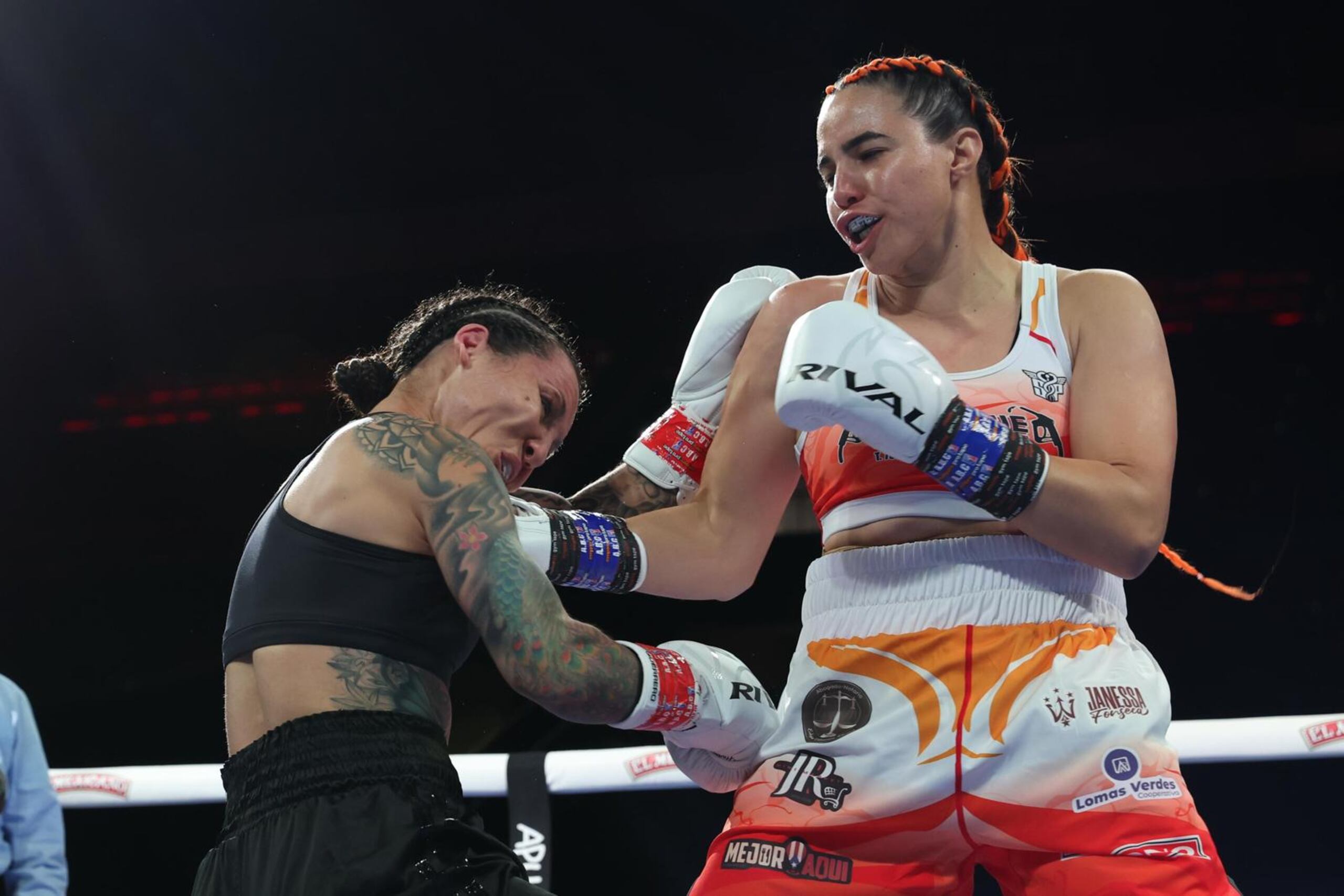 Stephanie Piñeiro (blanco y rojo) pega una derecha al rostro de Kalindra Faria durante la pelea en el Coliseo Roberto Clemente.