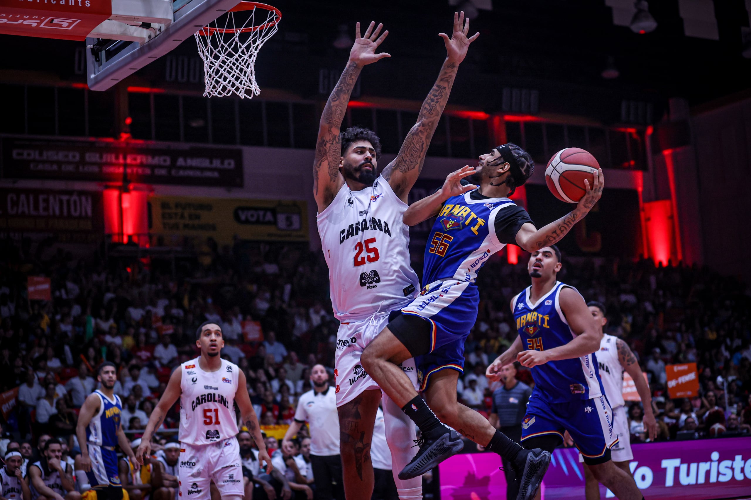 Jhivvan Jackson, de los Osos de Manatí, lanza un incómodo canasto frente la defensa de Julián Torres, de los Gigantes de Carolina.