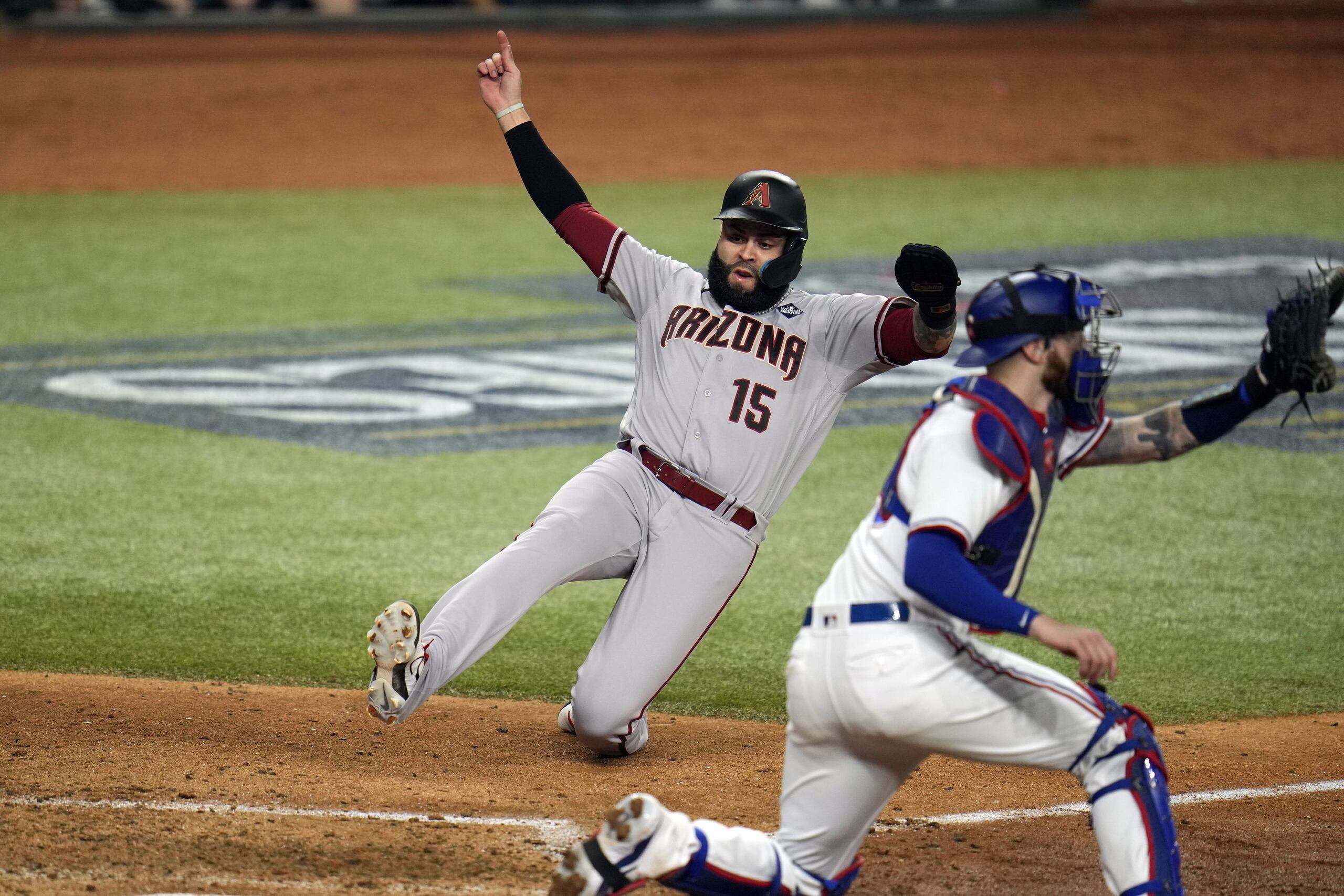 El puertorriqueño Emmanuel Rivera, de los Diamondbacks, se desliza en el plato para anotar contra los Rangers en la octava entrada del segundo partido de la Serie Mundial.