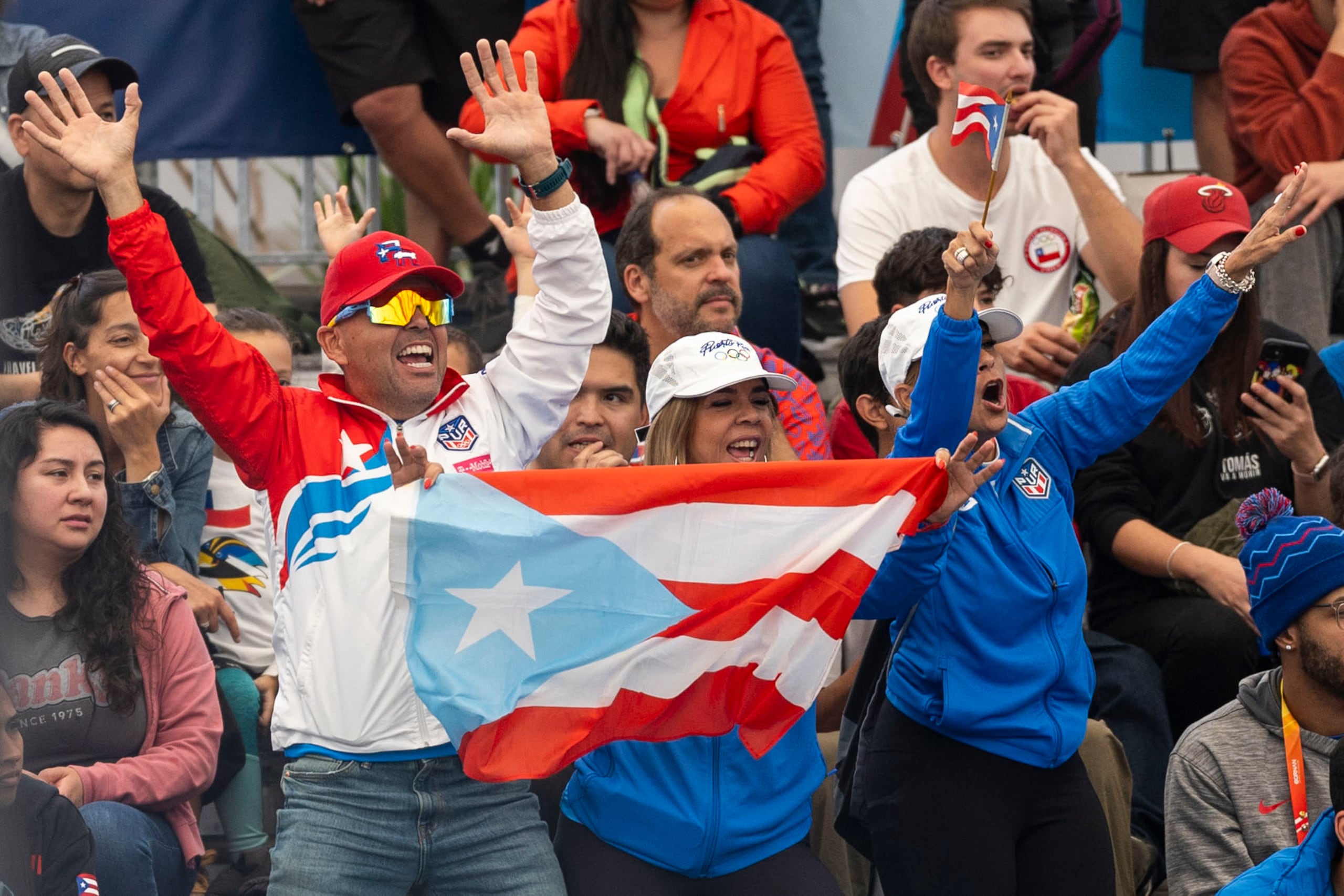 Un grupo de puertorriqueños celebra una de las victorias de los boricuas esta tarde en Santiago.