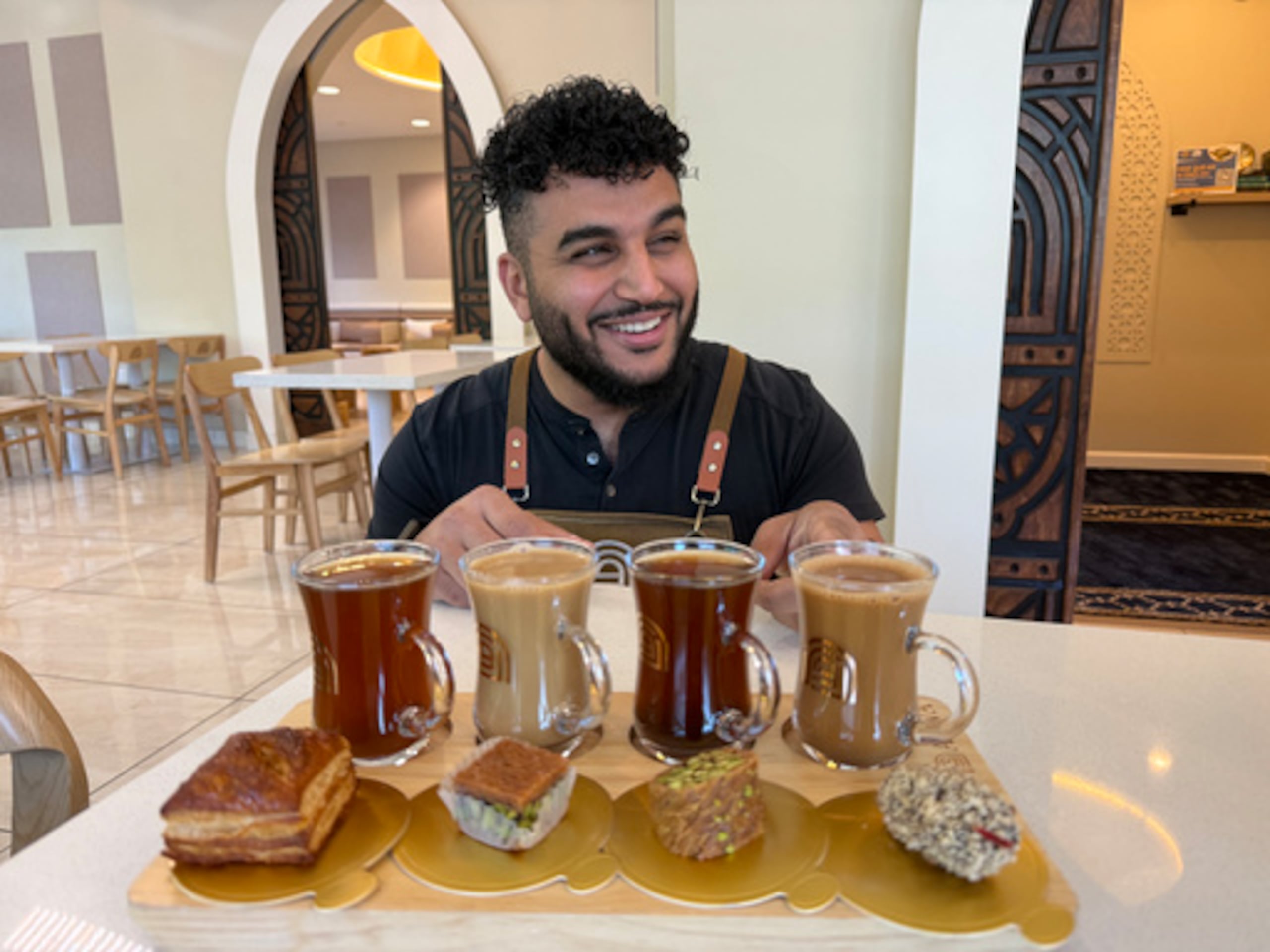 El franquiciado Ahmad Badr sirve un muestrario de bebidas y golosinas en Arwa Yemeni Coffee.
