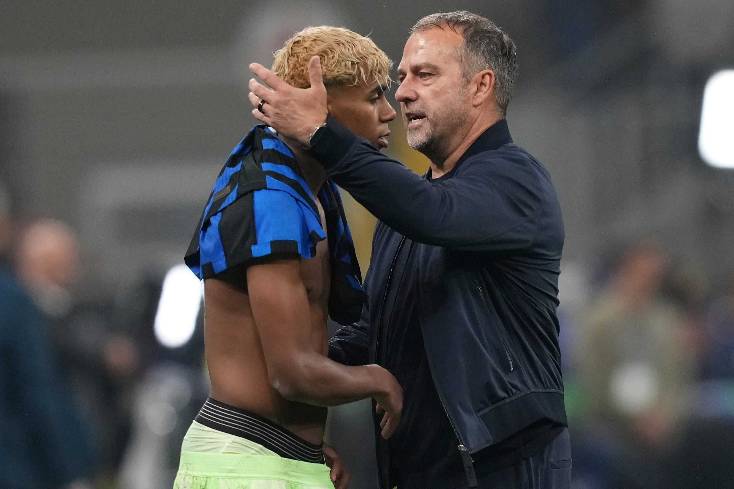 El técnico del Barcelona, Hansi Flick, consuela a Lamine Yamal tras la eliminación en las semifinales de la Liga de Campeones, el martes 6 de mayo de 2025, en Milán.