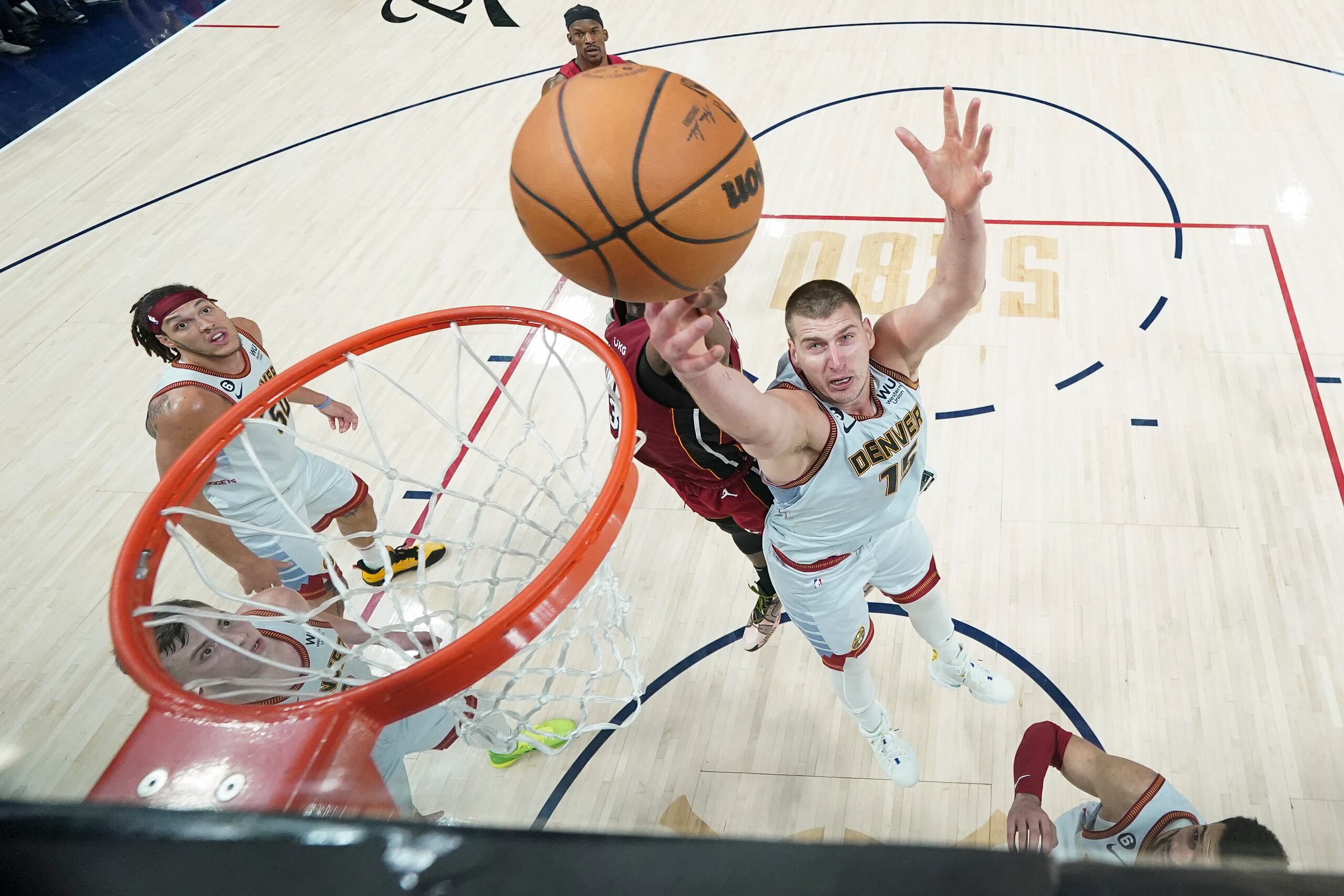 El pívot de los Nuggets de Denver Nikola Jokic y el pívot del Heat de Miami Bam Adebayo pelean por un rebote.