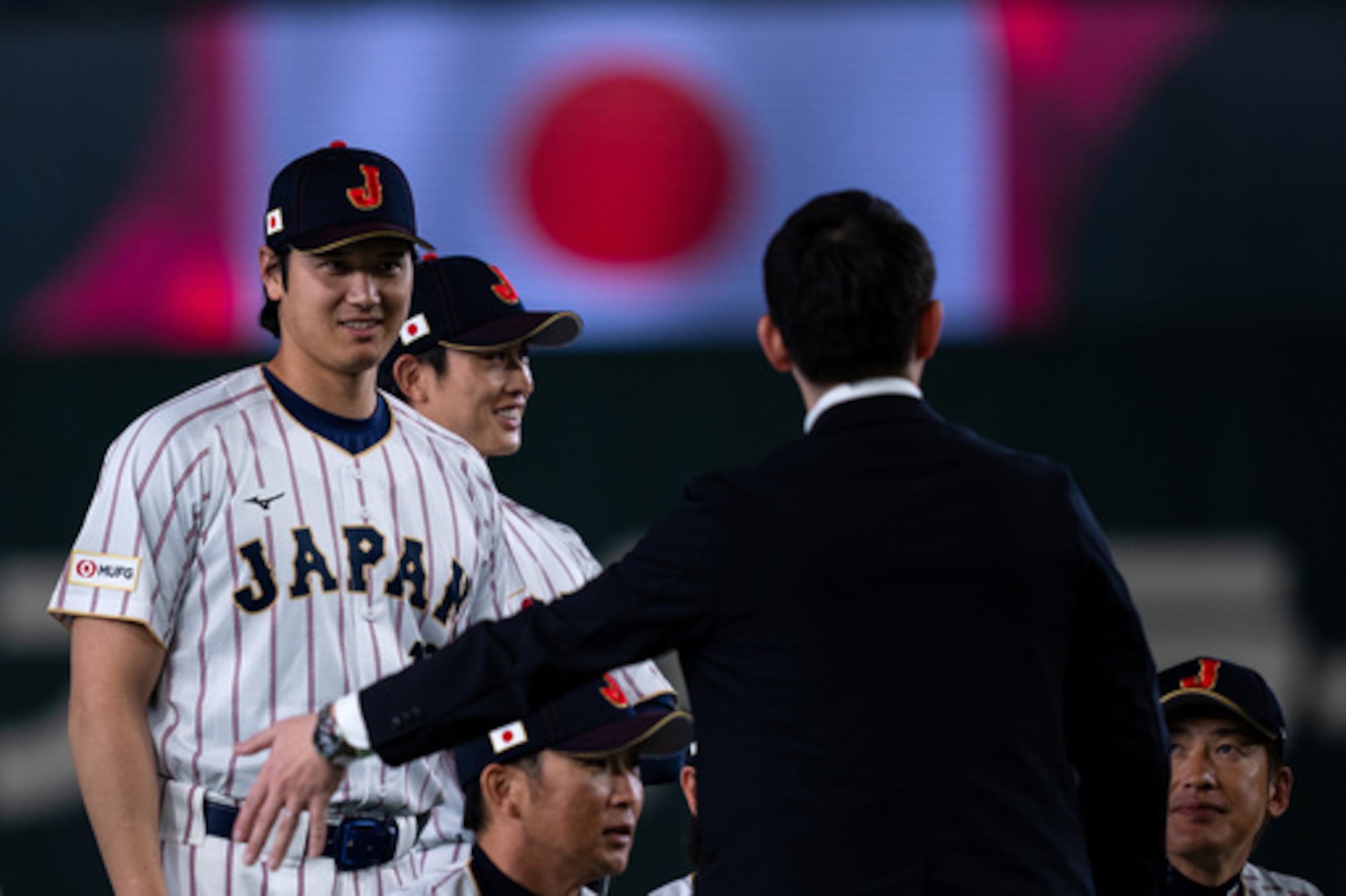 El japonés Shohei Ohtani, a la izquierda, de pie durante una sesión de fotos de grupo junto con otros miembros del equipo antes de su sesión de práctica antes de los juegos del Clásico Mundial de Béisbol en Tokio, el miércoles 4 de marzo de 2026. (AP Photo/Louise Delmotte)