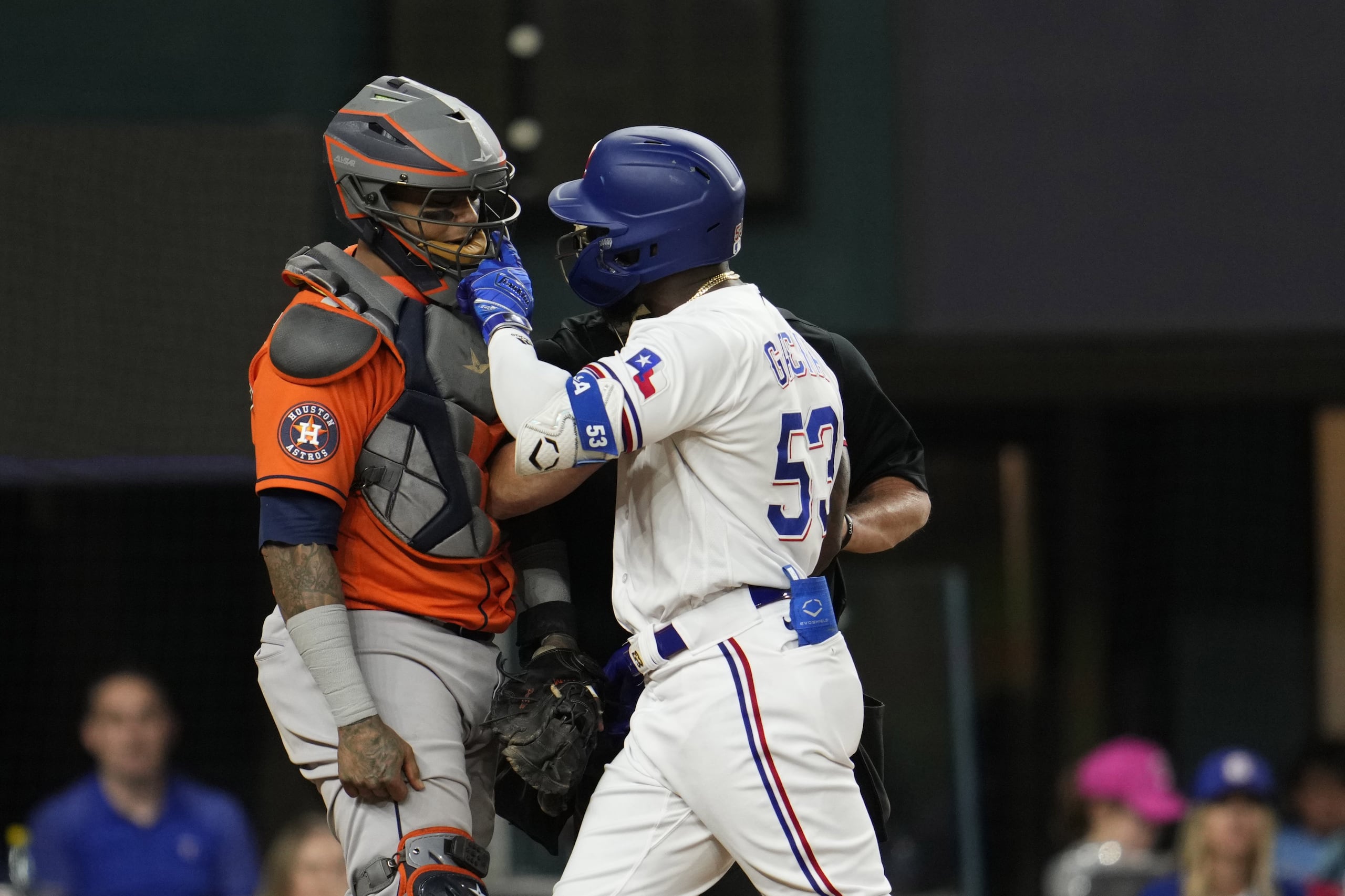 Adolis García, toletero cubano de los Rangers, reclama al receptor boricua Martín Maldonado, de los Astros, por un pelotazo recibido.