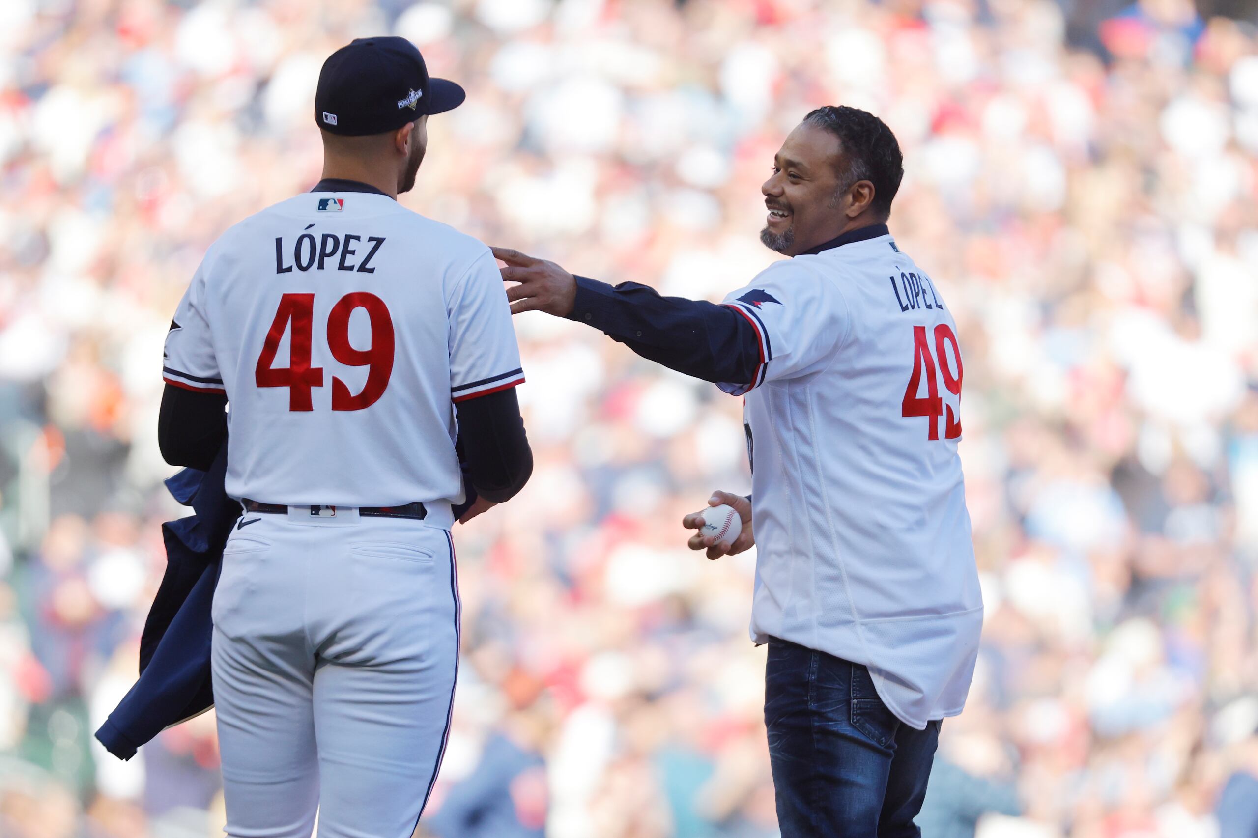 El exlanzador de los Mellizos de Minnesota, Johan Santana (derecha), habla con su compatriota venezolano Pablo López, antes de hacer el primer lanzamiento del tercer juego de la serie divisional de la Liga Americana, ante los Astros de Houston (AP Foto/Bruce Kluckhorn)