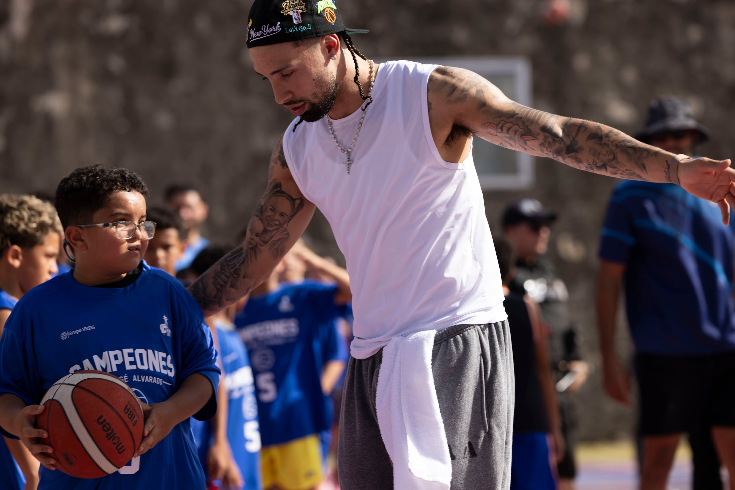 José Alvarado junto a uno de los niños que asistió a su clínica de baloncesto en La Perla.