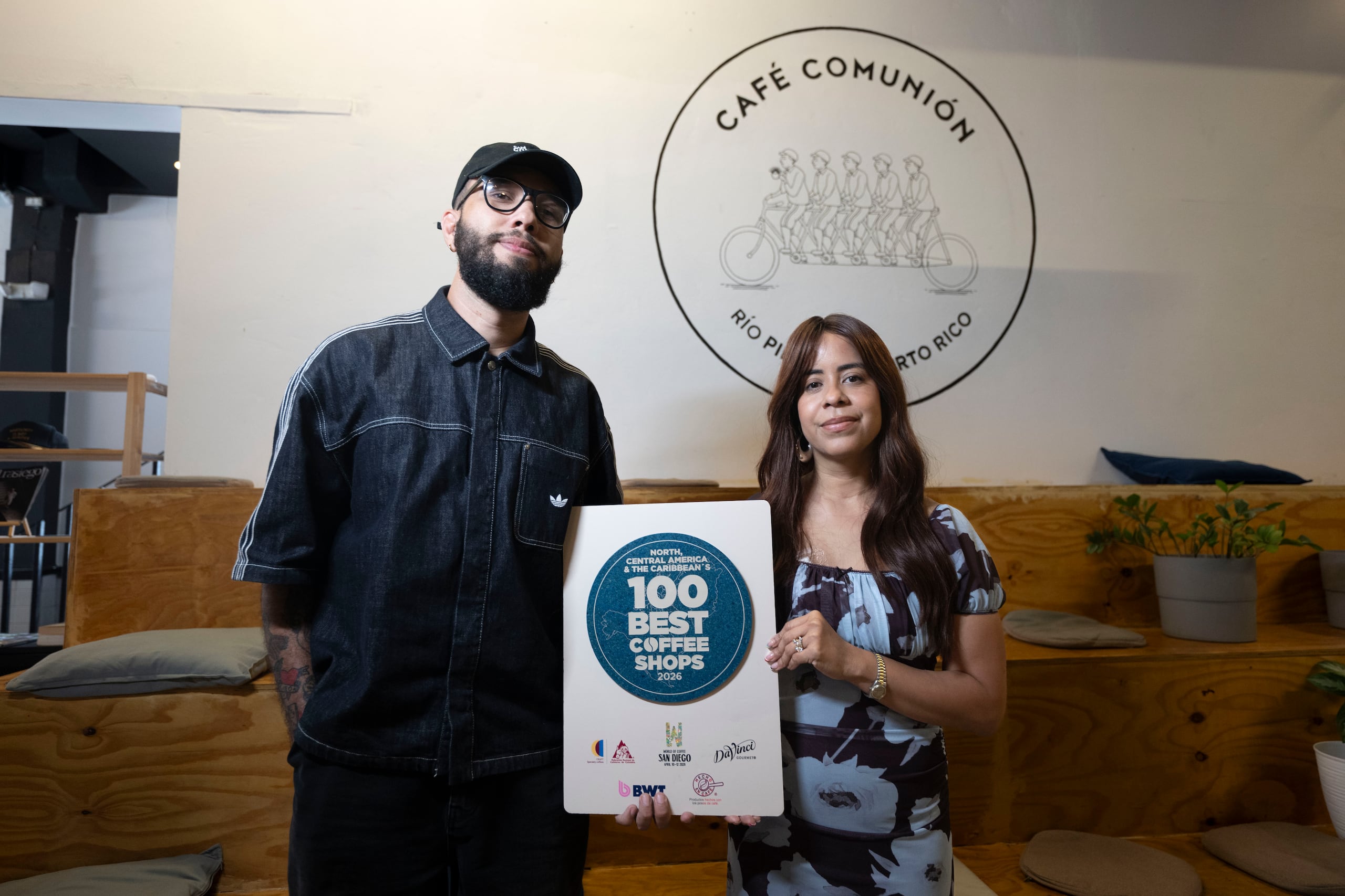 La pareja con la placa que acredita a su proyecto como uno de los mejores 100 de la región.