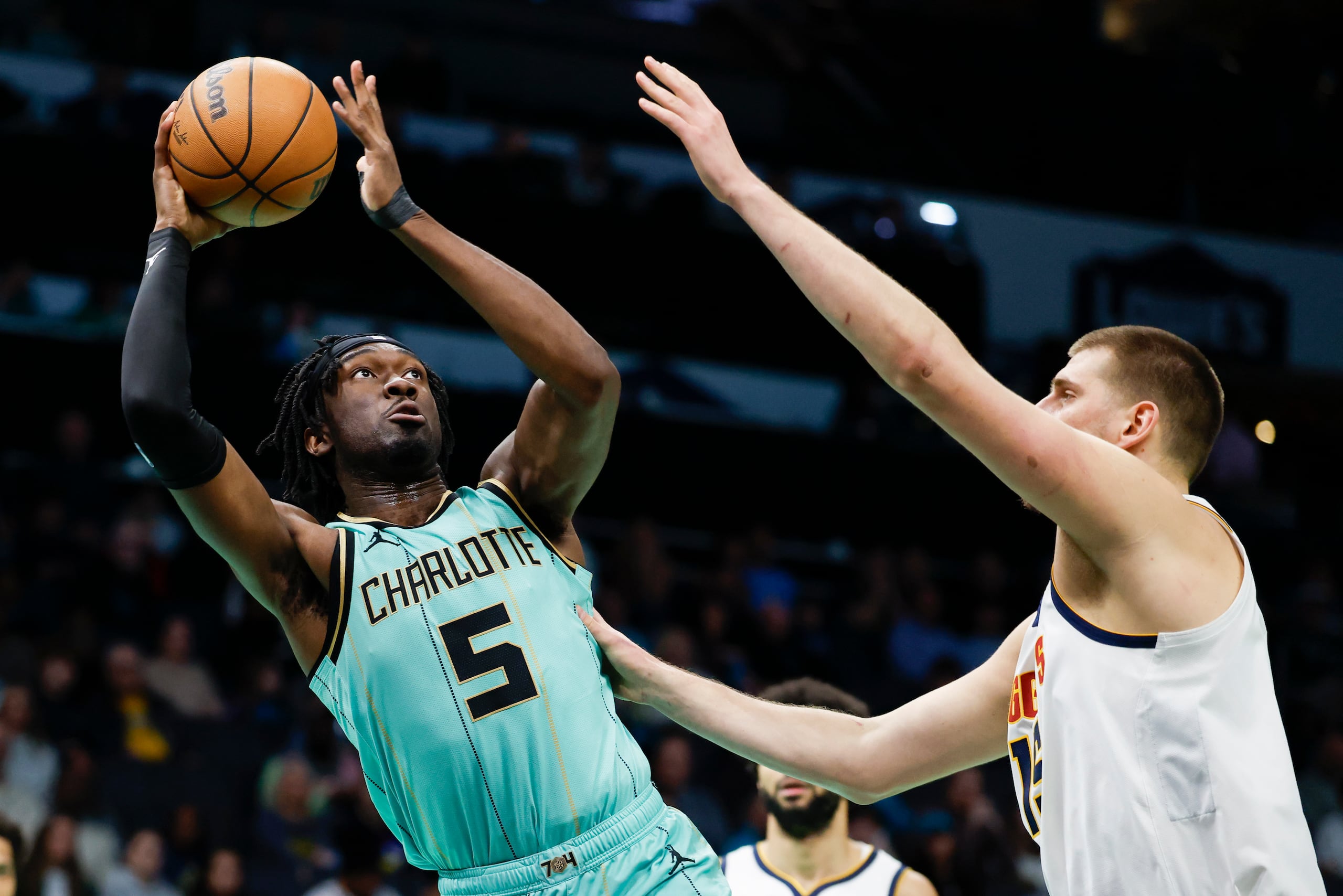 El pívot de los Hornets de Charlotte, Mark Williams (5), busca disparar contra el pívot de los Nuggets de Denver, Nikola Jokic, a la derecha, durante la primera mitad de un partido de baloncesto de la NBA en Charlotte, Carolina del Norte, el sábado 1 de febrero de 2025.