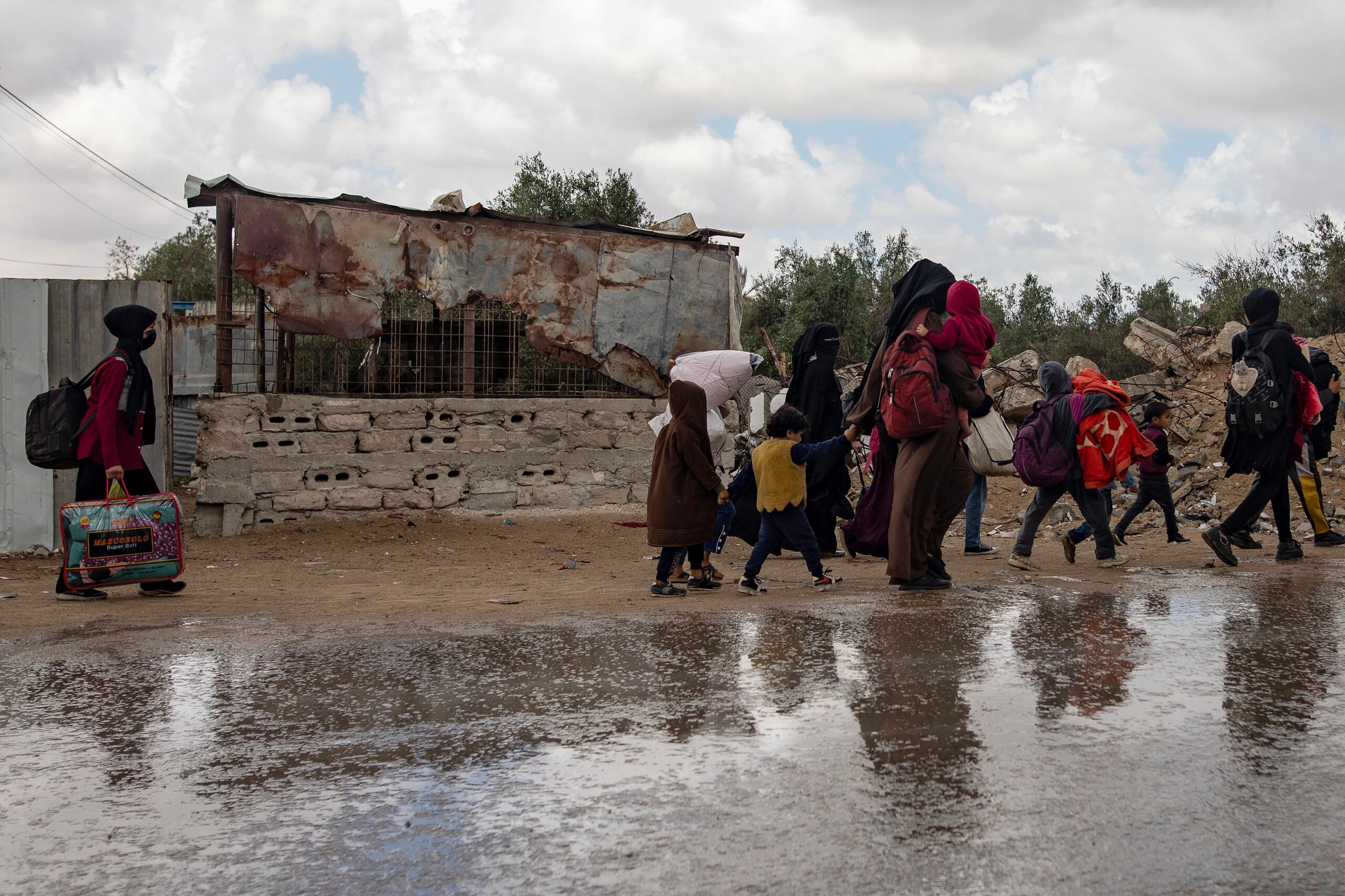 Fotografía de palestinos desplazados internos, entre ellos mujeres y niños, mientrascargan sus pertenencias tras una orden de evacuación emitida por el ejército israelí, en Rafah, en el sur de la Franja de Gaza. EFE/EPA/Haitham Imad