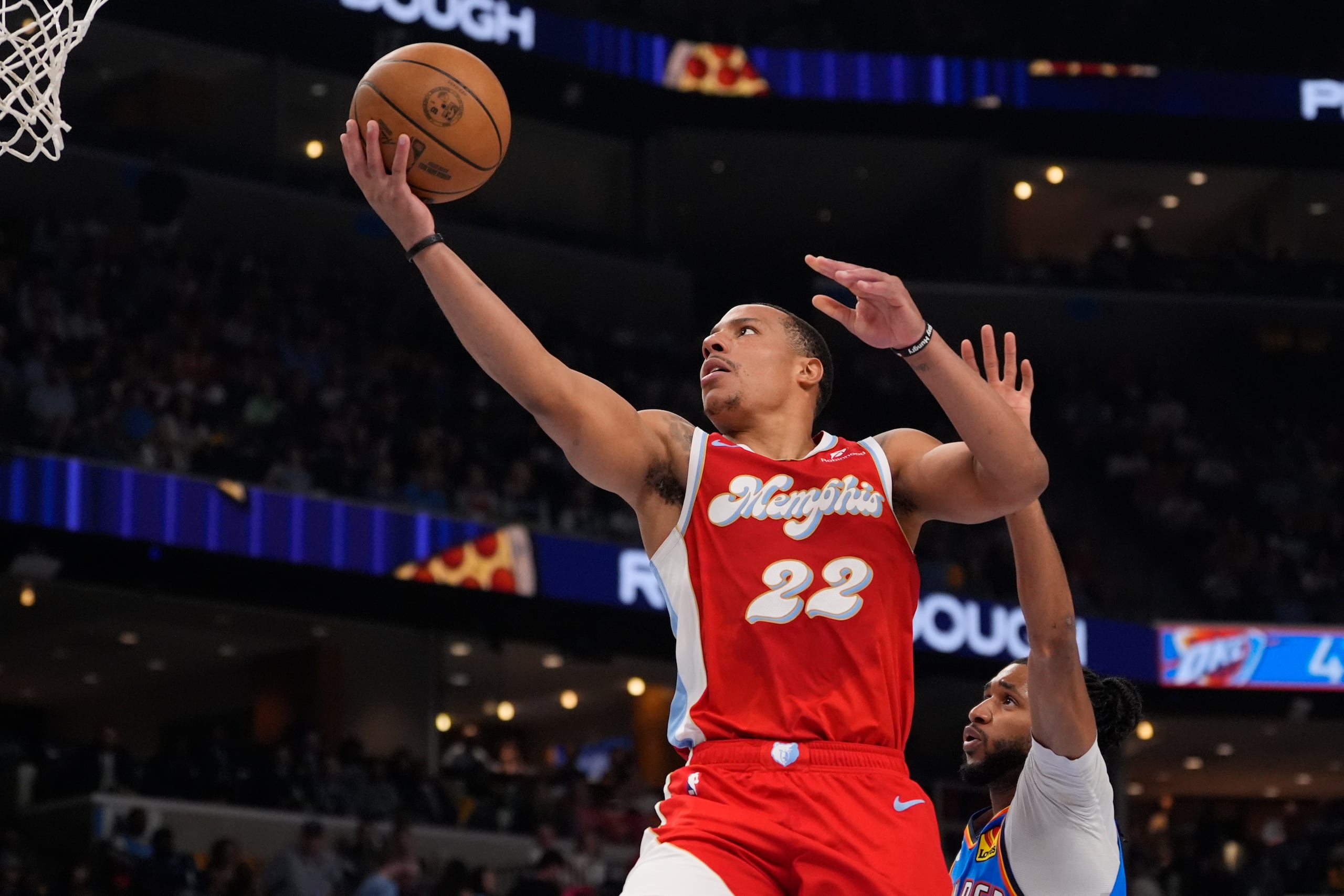 El base de los Grizzlies de Memphis Desmond Bane lanza el balón frente al base del Thunder de Oklahoma City.