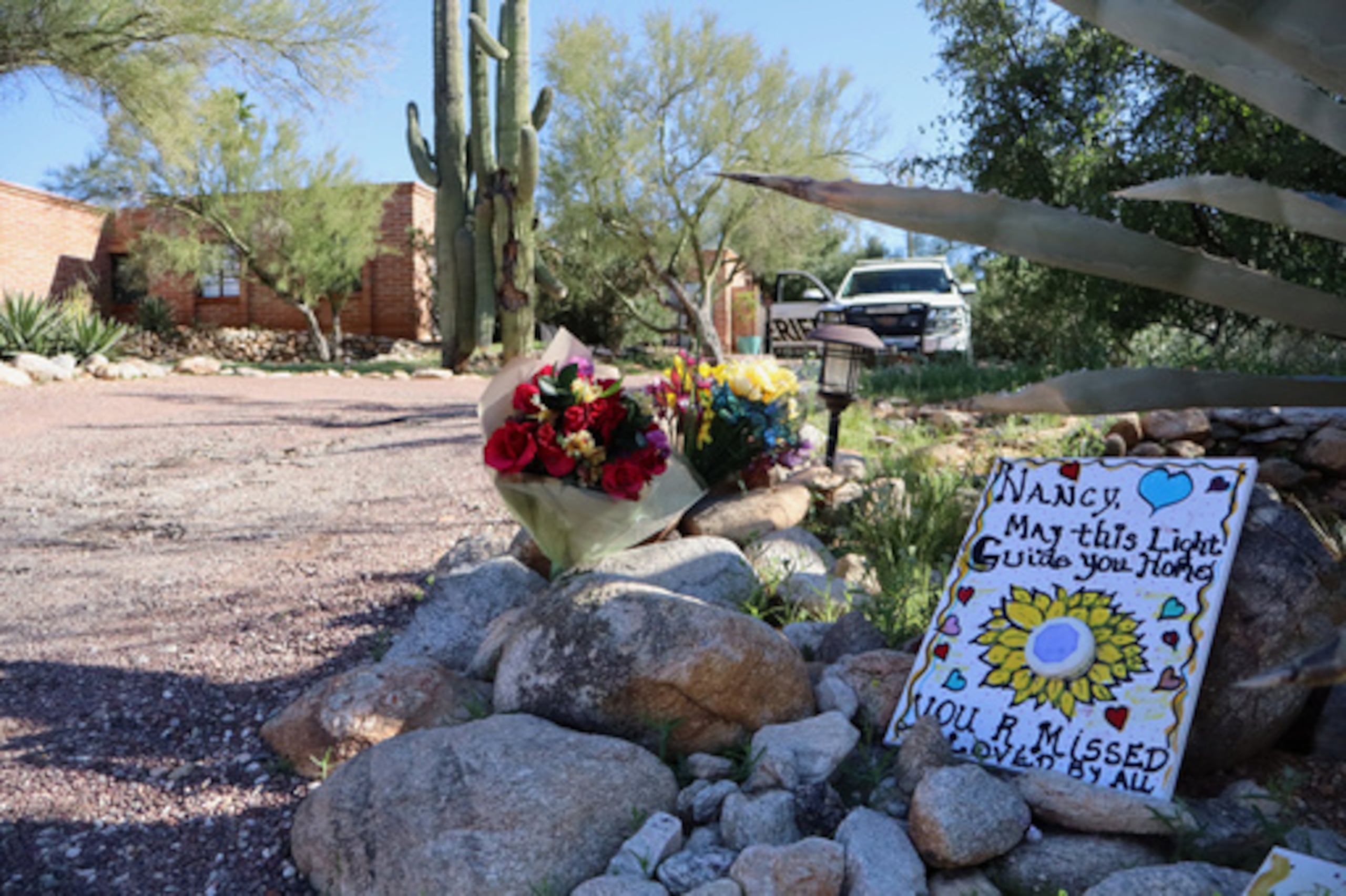 Un monumento crece frente a la casa de Nancy Guthrie, la madre desaparecida de la presentadora del programa "Today" Savannah Guthrie, en Tucson, Arizona, el domingo 22 de febrero de 2026. (AP Photo/Felicia Fonseca)