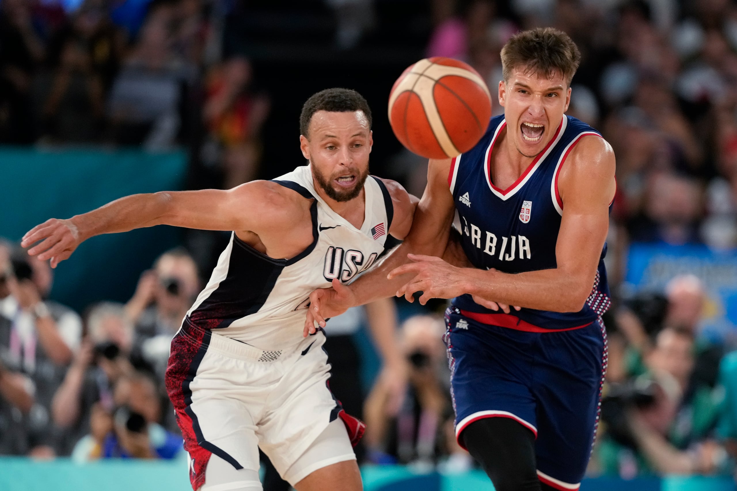 Stephen Curry (4) y Bogdan Bogdanovic (7) pelean un balón durante el partido del jueves.