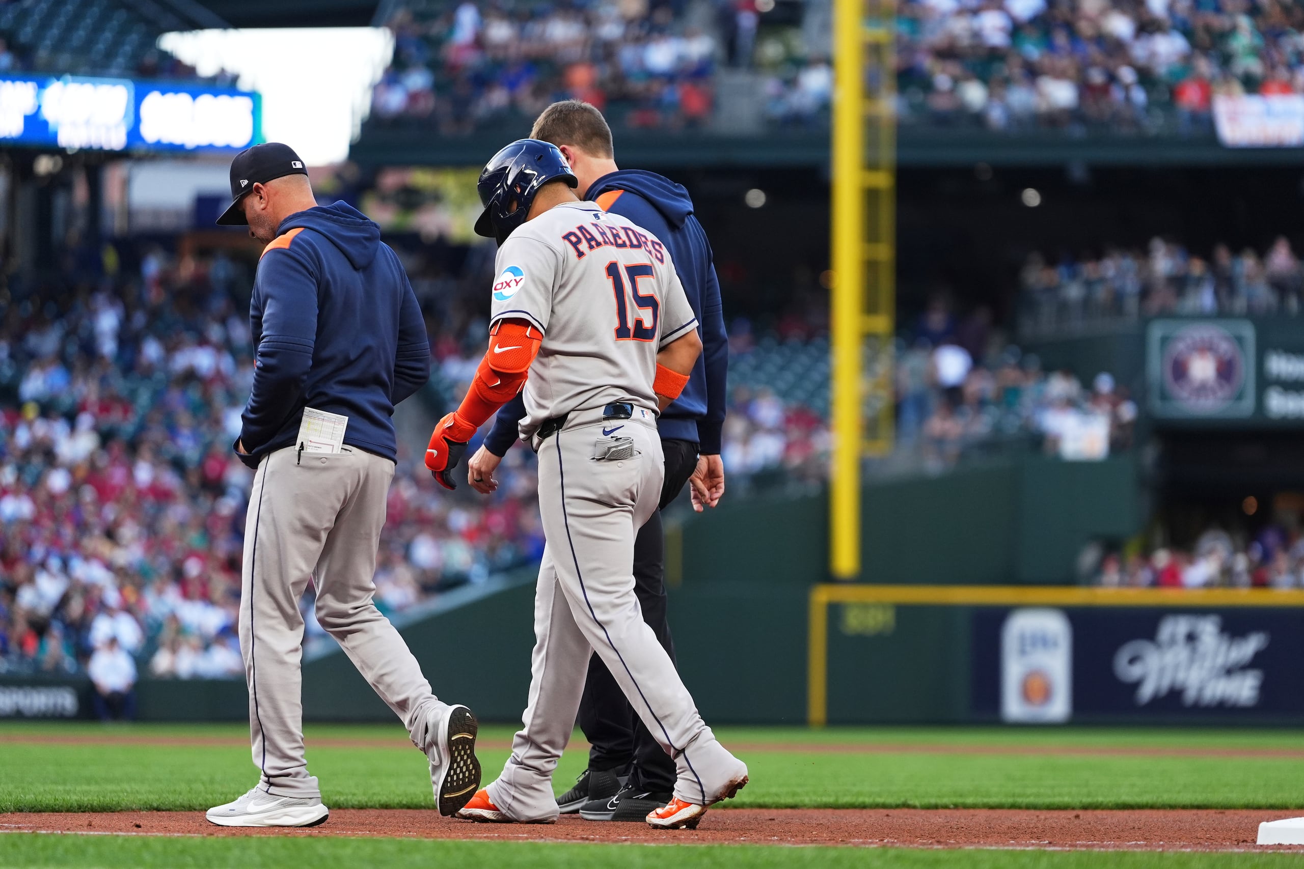 Isaac Paredes (15), de los Astros de Houston, camina de regreso al dugout del equipo con una aparente lesión que sufrió después de correr a primera base en un sencillo frente a los Marineros de Seattle durante la tercera entrada del juego de béisbol de Grandes Ligas, el sábado 19 de julio de 2025, en Seattle.