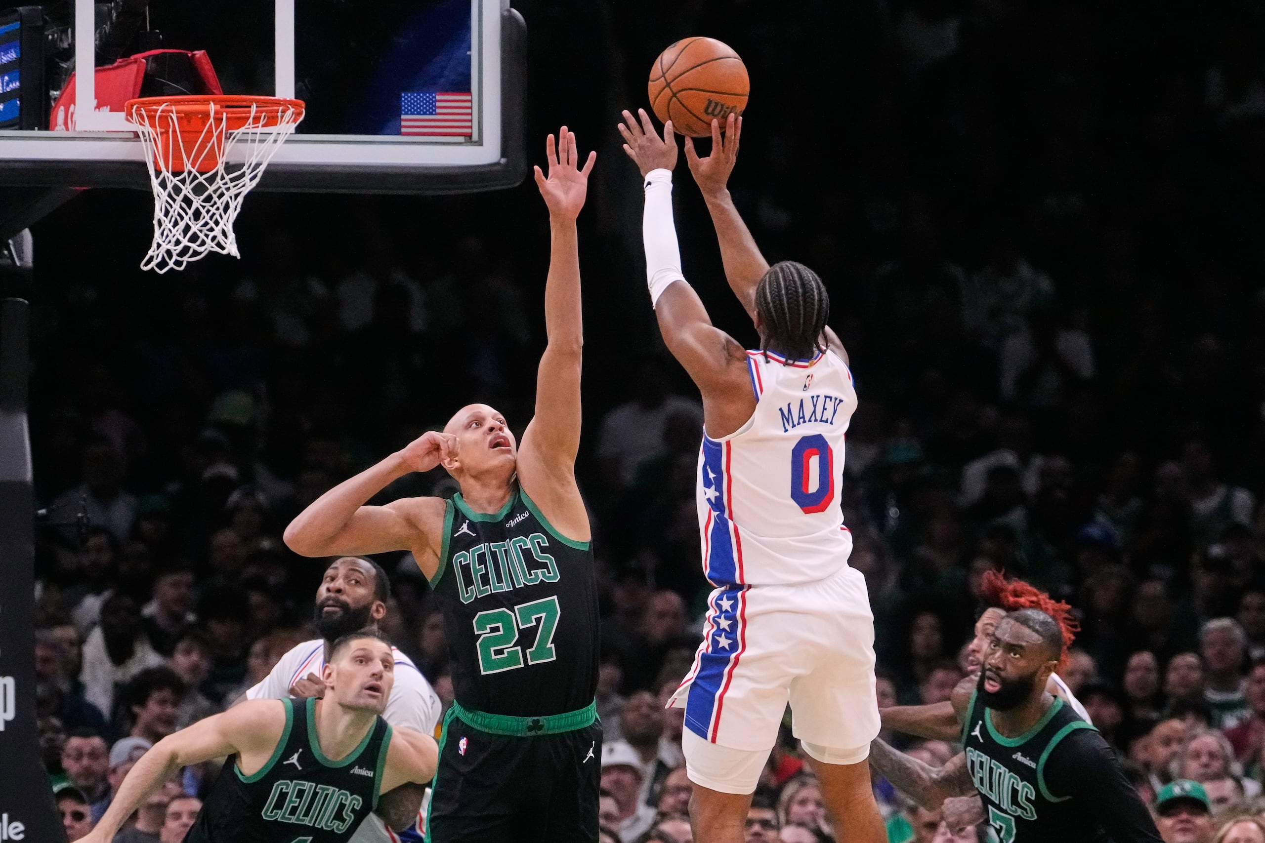 El base de los 76ers de Filadelfia, Tyrese Maxey (0), realiza un tiro por encima del base de los Celtics de Boston, Jordan Walsh (27), durante la primera mitad del quinto juego de una serie de la primera ronda de los playoffs de la NBA, el martes 28 de abril de 2026, en Boston.