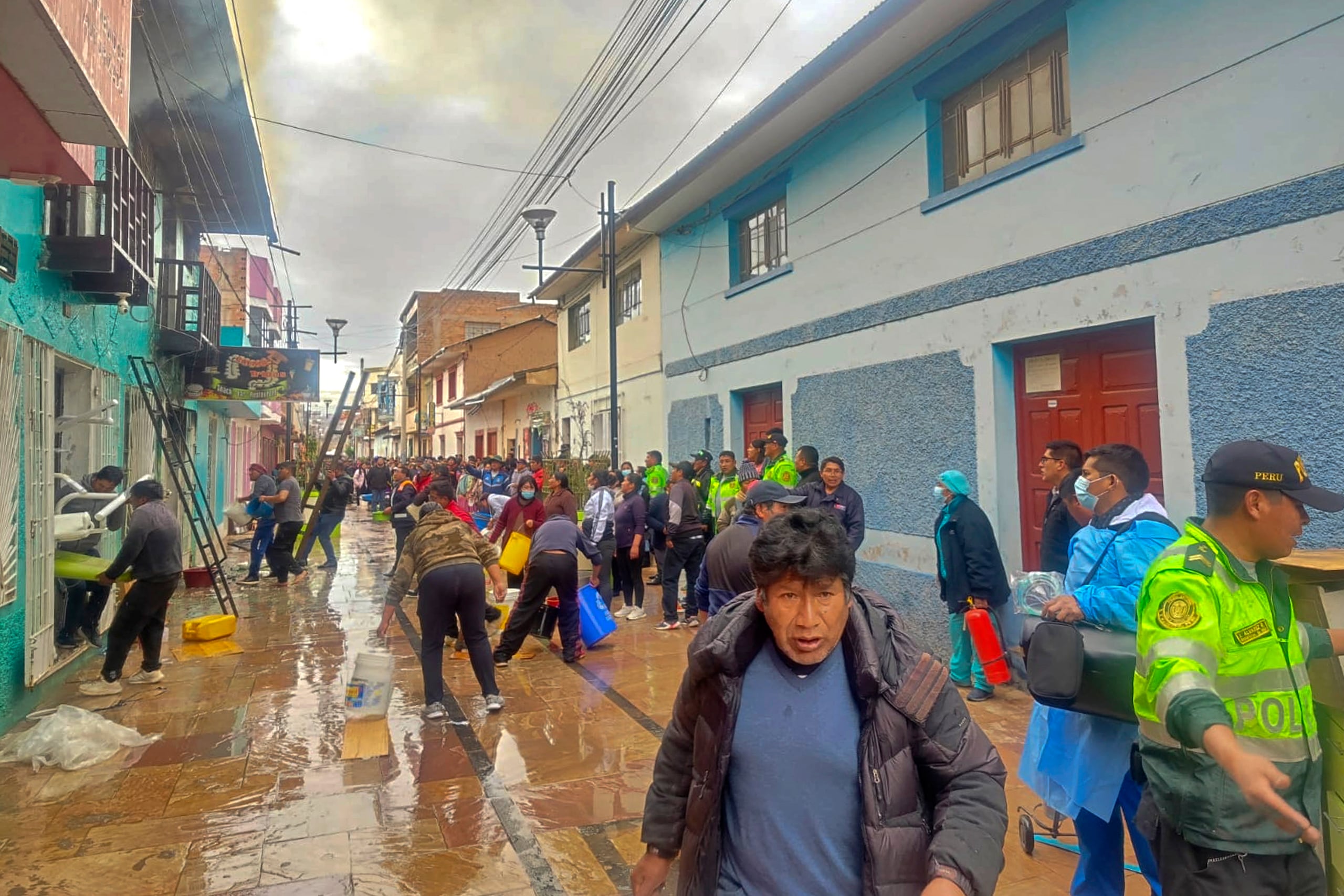 Handout picture released by the Peruvian National Police showing police officers and residents trying to extinguish a fire in Huancane, Puno department, southern Peru on December 5, 2025. Ten university students died and three were injured in a restaurant fire in southeastern Peru while they were gathered for a birthday celebration, police said Friday. (Photo by Handout / Peruvian National Police / AFP) / RESTRICTED TO EDITORIAL USE - MANDATORY CREDIT AFP PHOTO / PERUVIAN NATIONAL POLICE - NO MARKETING NO ADVERTISING CAMPAIGNS - DISTRIBUTED AS A SERVICE TO CLIENTS
