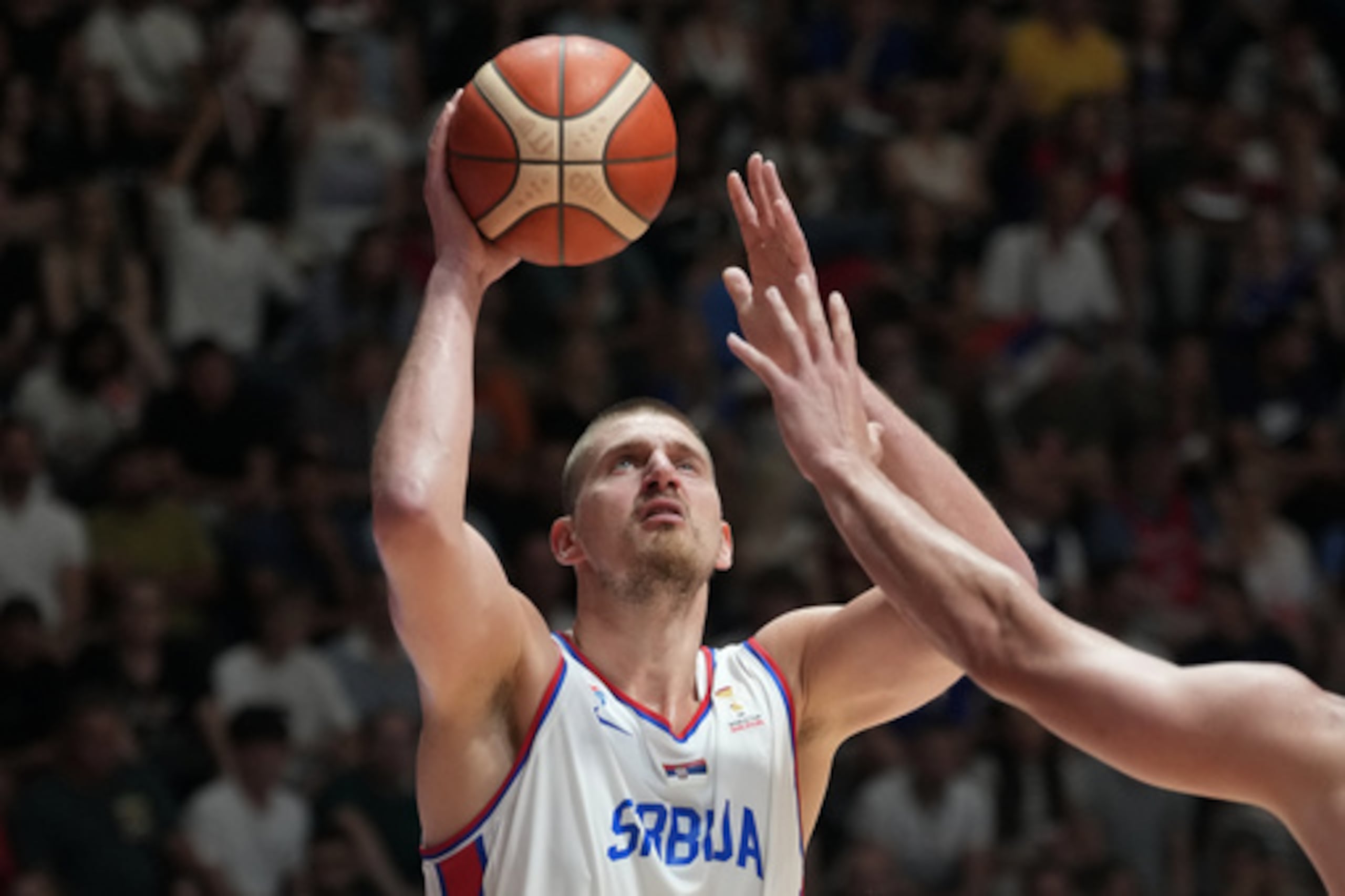 Nikola Jokic, de Serbia, intenta anotar mientras Luka Garza, de Bosnia, le bloquea durante el partido de clasificación para la Copa del Mundo de Baloncesto de la FIBA 2027 entre Serbia y Bosnia, celebrado en Belgrado, Serbia, el lunes 6 de julio de 2026. (Foto AP/Darko Vojinovic)