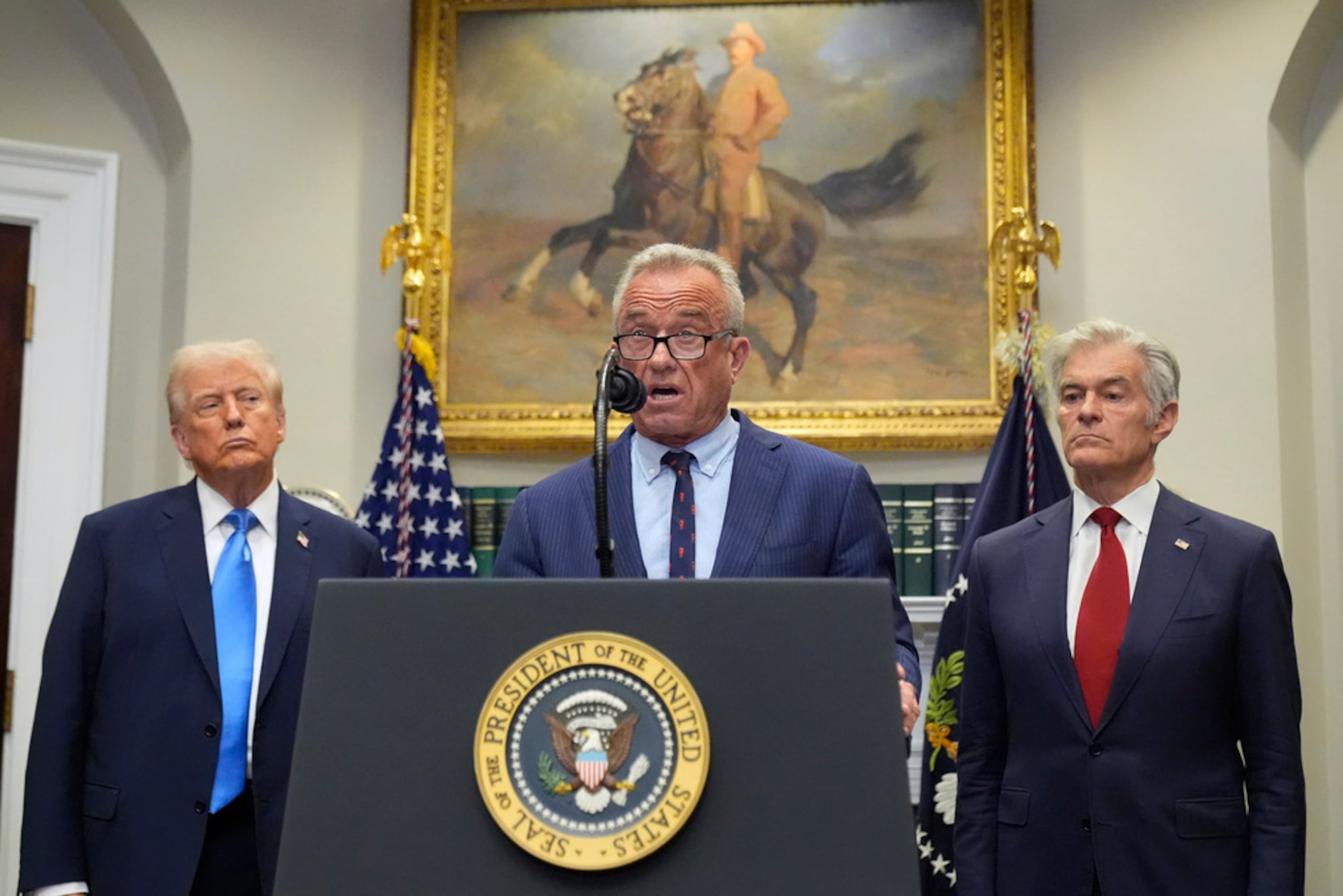 El presidente Donald Trump y el administrador de los Centros de Servicios de Medicare y Medicaid, Mehmet Oz, escuchan mientras el secretario de Salud y Servicios Humanos, Robert F. Kennedy Jr., habla en la Sala Roosevelt de la Casa Blanca, el 22 de septiembre de 2025, en Washington.
