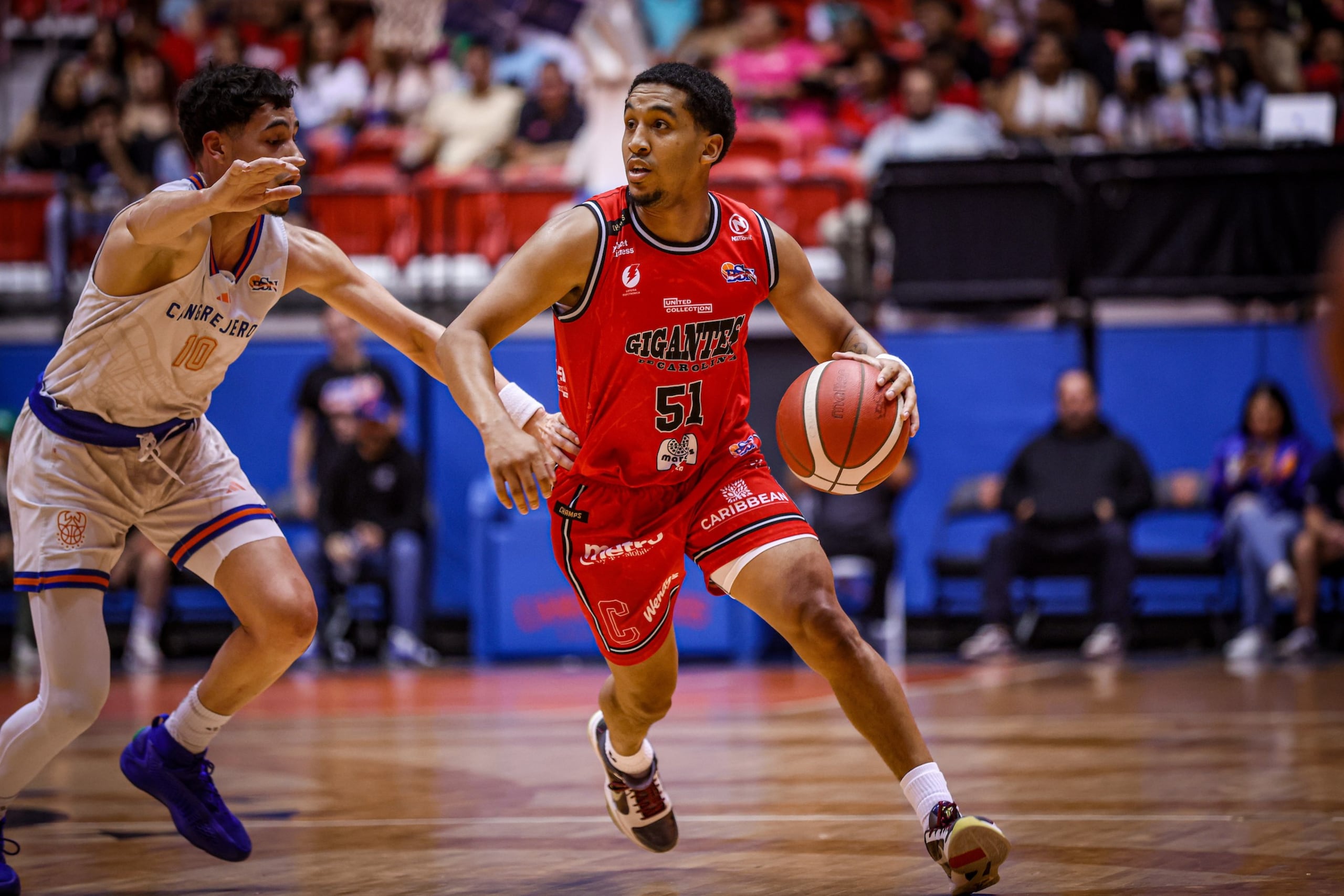Tremont Waters maneja el balón ante la presión de Emmanuel Maldonado en un juego entre los Gigantes de Carolina y los Cangrejeros de Santurce en la temporada 2024 del BSN.