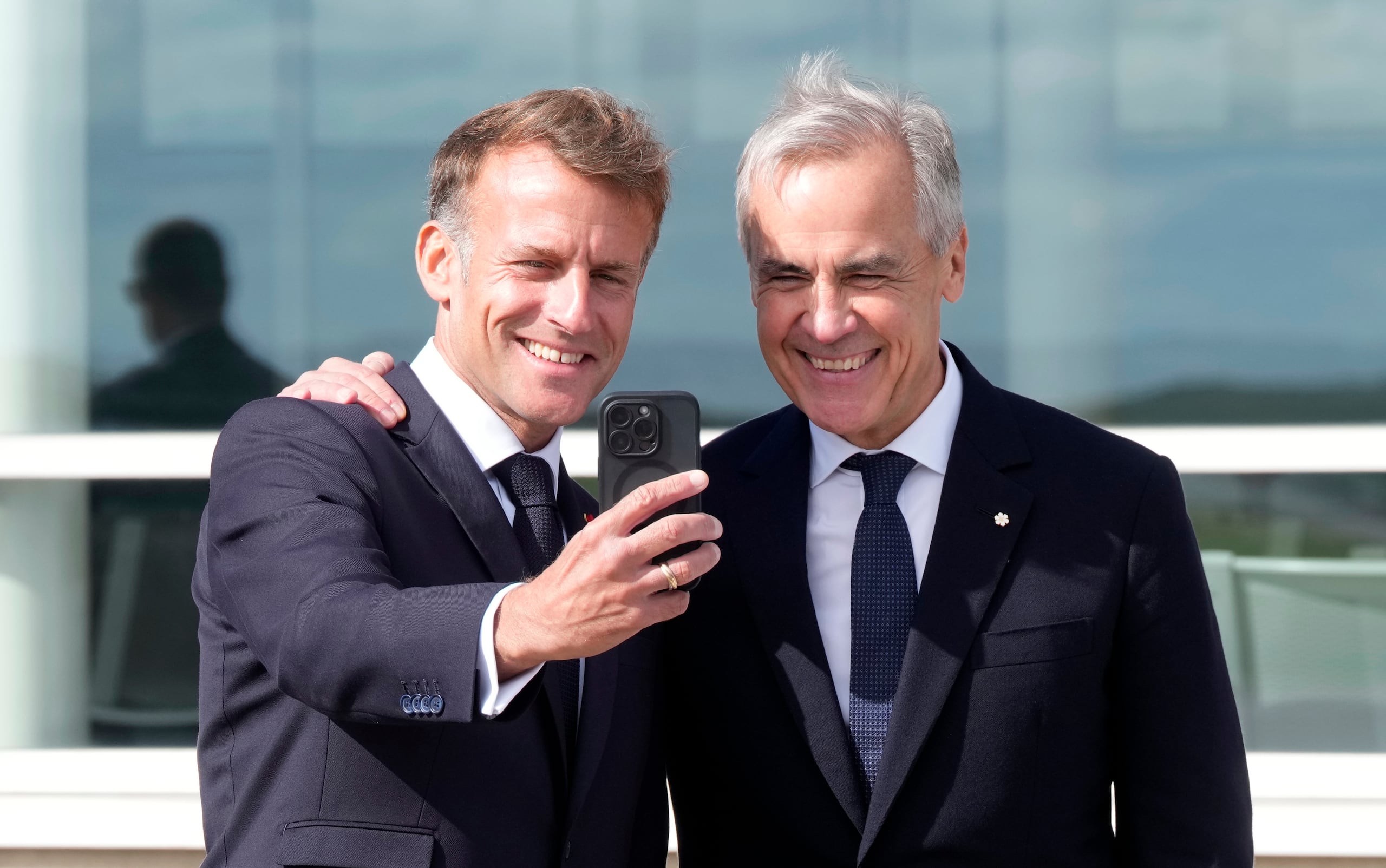 El presidente francés Emmanuel Macron, izquierda, se toma una selfie con el primer ministro canadiense Mark Carney tras pronunciar un discurso, el domingo 20 de septiembre de 2026, en Saint-Pierre, San Pedro y Miquelón. (Adrian Wyld/The Canadian Press vía AP)
