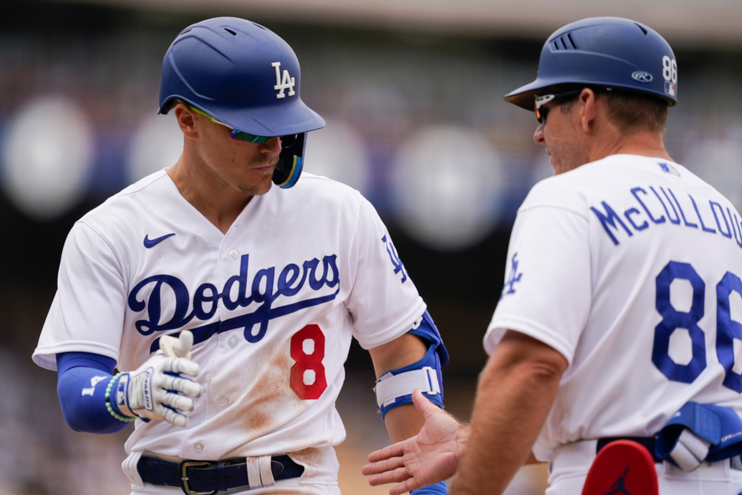 Kiké Hernández saluda al coach de primera base Clayton McCullough después de conectar un sencillo en la octava entrada.