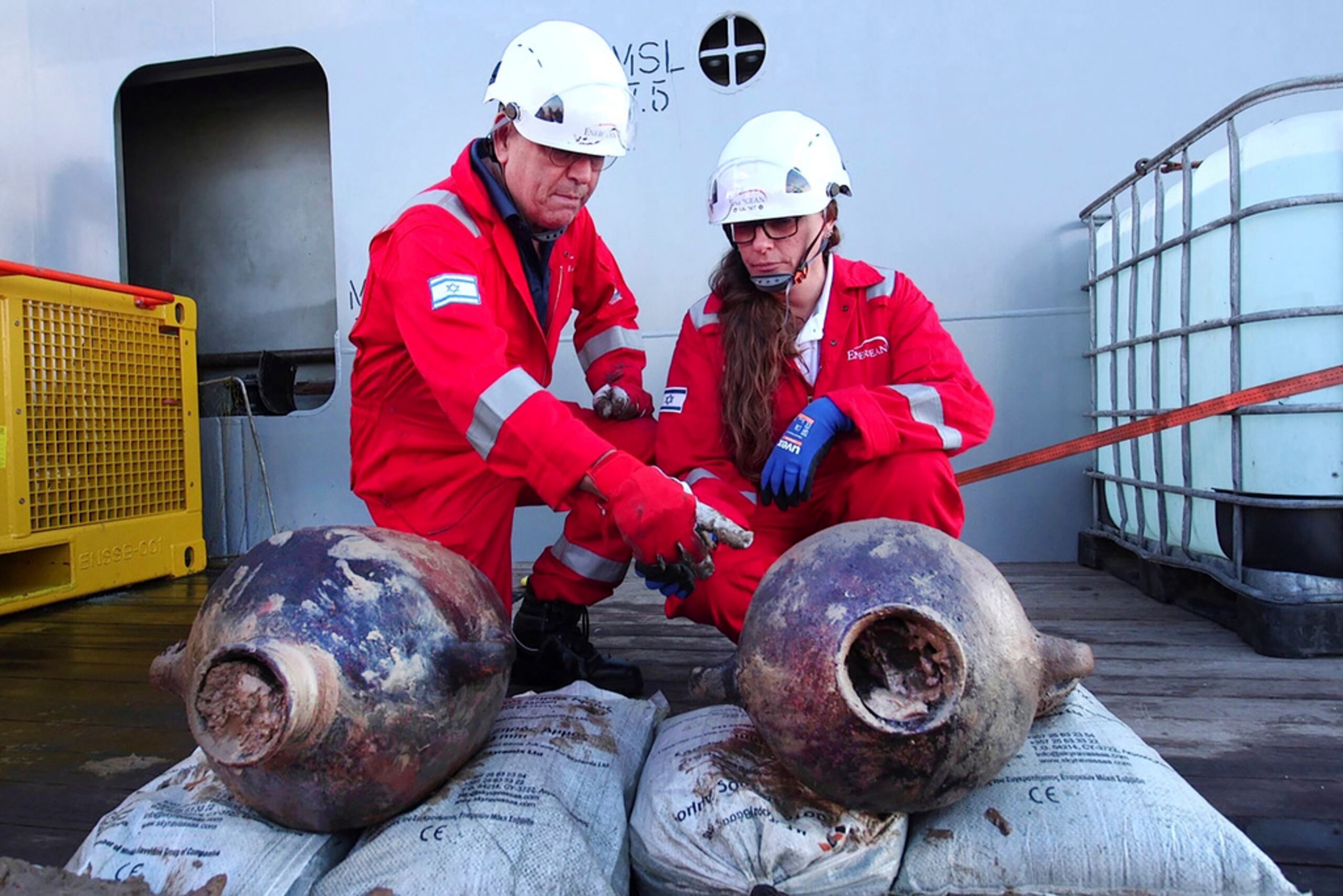 Jacob Sharvit y Karnit Bahartan con jarrones antiguos sacados del barco que descubrieron a unos 90 kilómetros de la costa israelí.