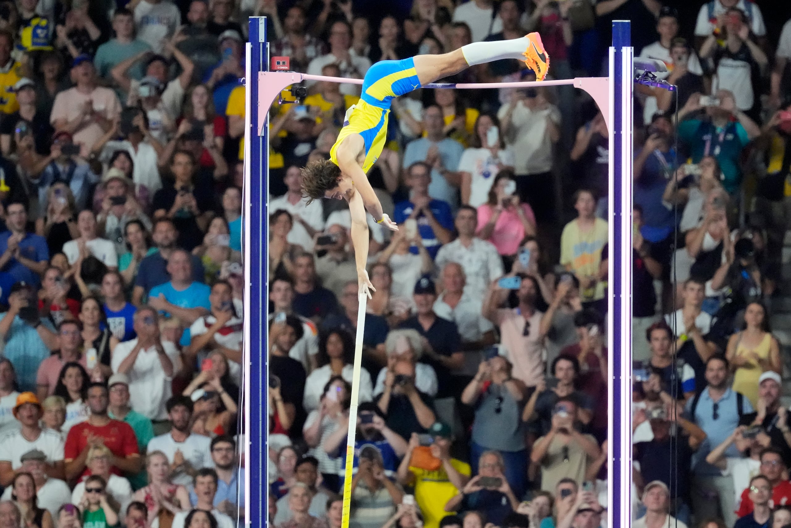 Armand Duplantis se ve aquí buscando un impulso final de su pértiga para superar la histórica altura, lo que hizo.