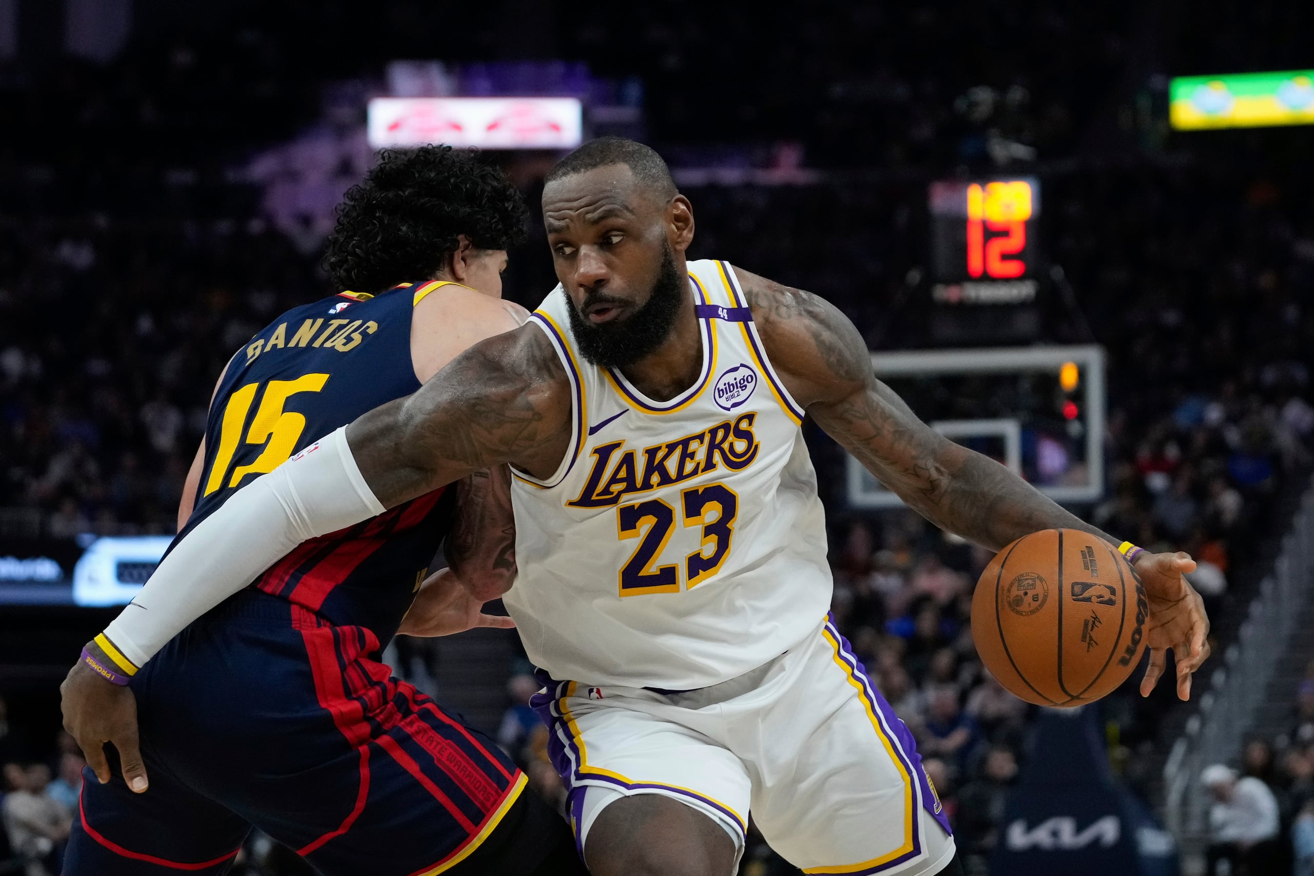 LeBron James, de los Lakers de Los Ángeles, avanza con el balón mientras lo defiende Gui Santos, de los Warriors de Golden State.