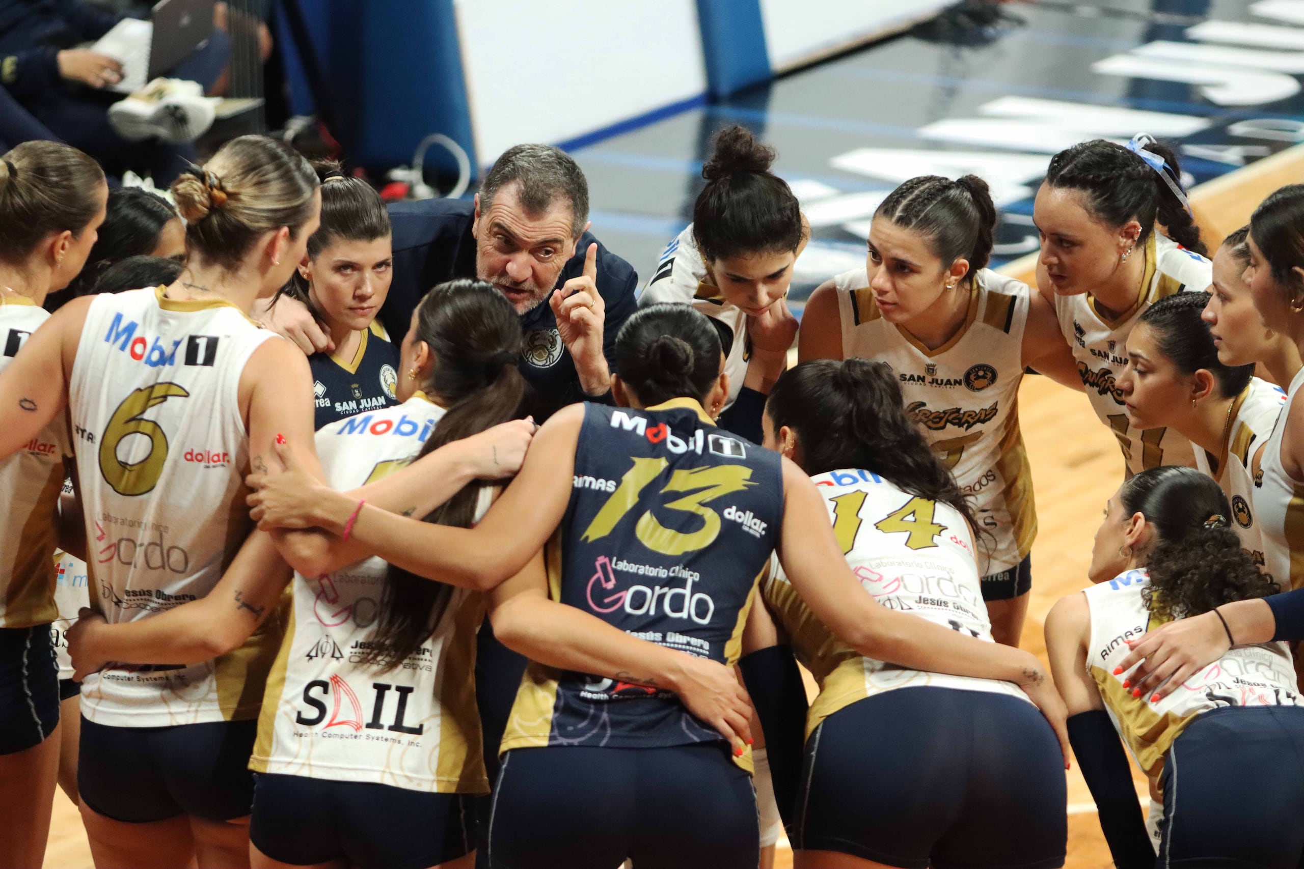 Las Cangrejeras de Santurce se reúnen con el técnico Pascual Saurín durante un tiempo técnico en el primer juego de la final de la LVSF contra las Criollas de Caguas.