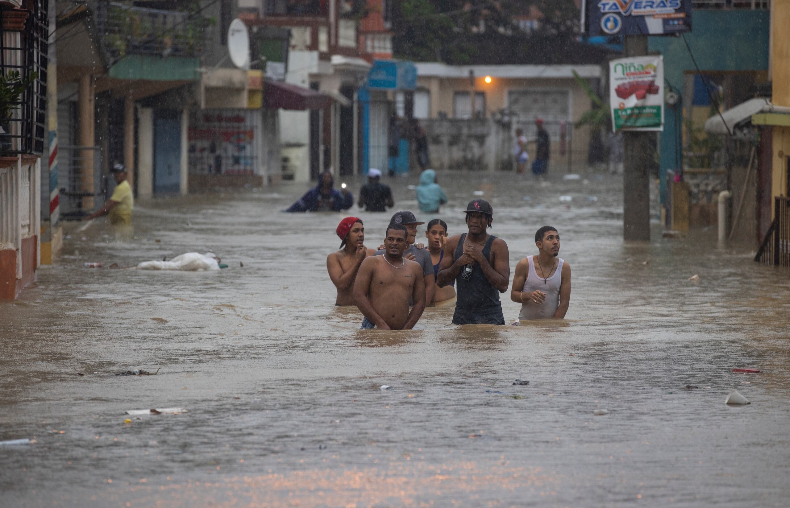 Personas caminan hoy por calles inundadas debido al paso de la tormenta tropical Franklin, en Santo Domingo (República Dominicana). EFE/Orlando Barría