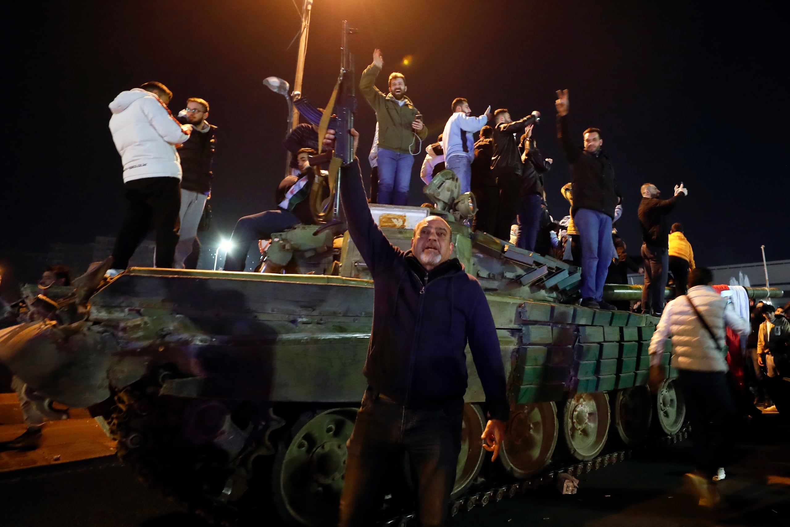Sirios celebran la llegada de combatientes de oposición a Damasco, en Siria.