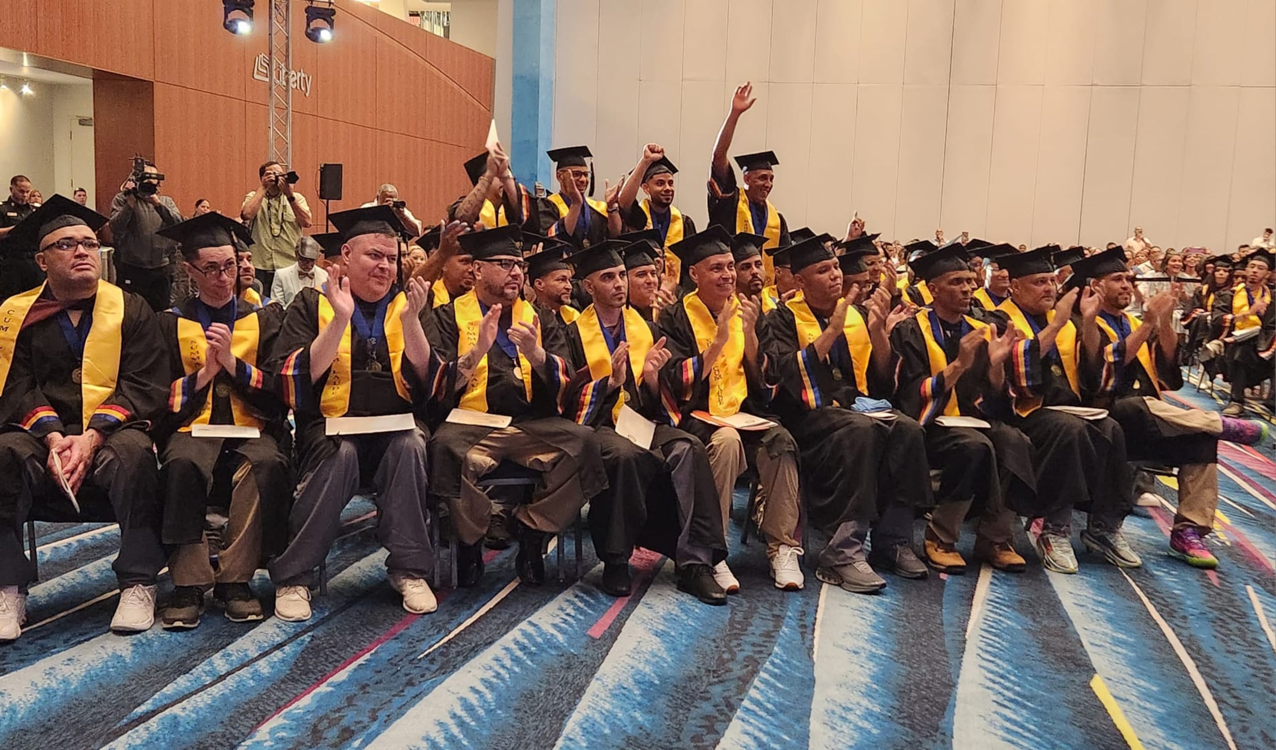 Grupo de confinados celebra durante su graduación en el Caribbean University.
