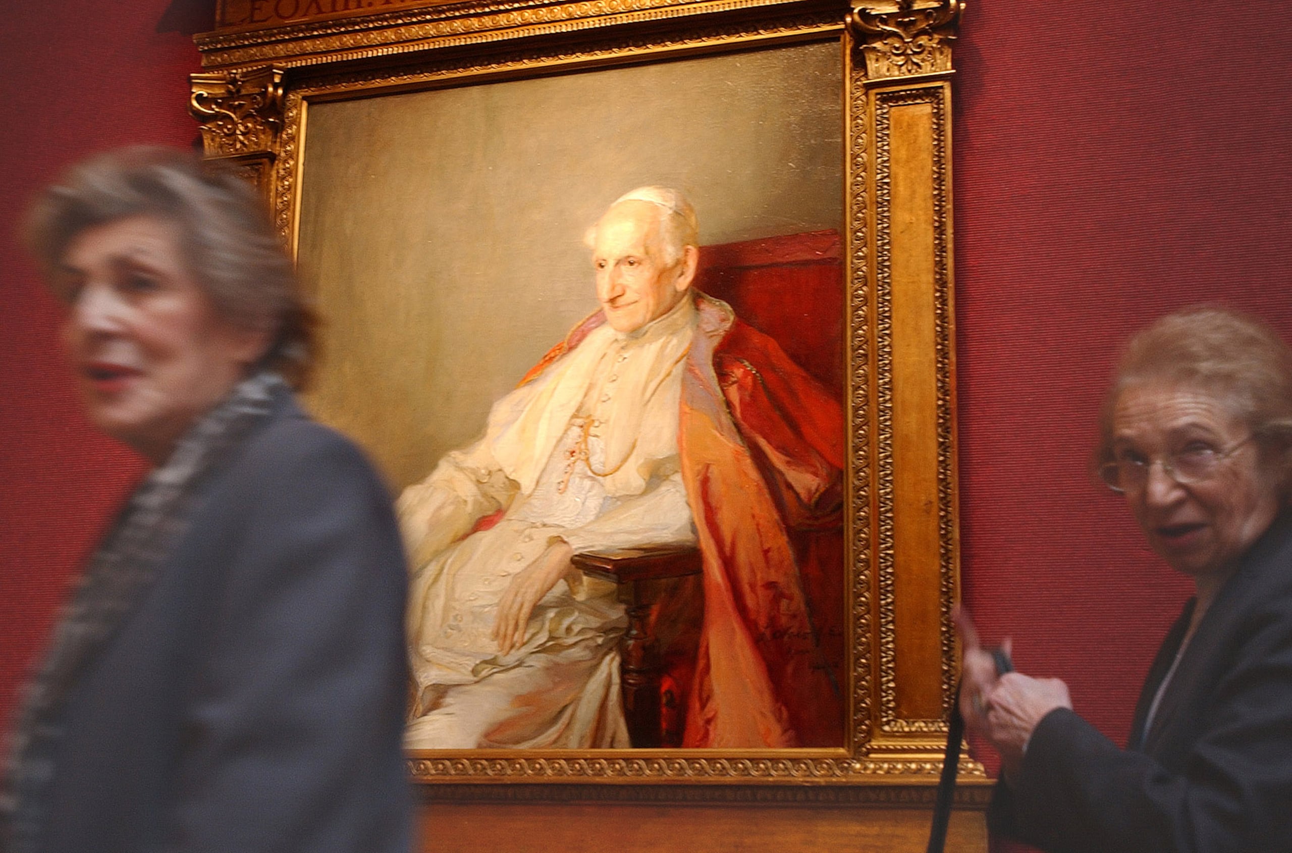 Dos mujeres pasan junto a una pintura del papa León XIII realizada en 1900 por el artista húngaro Philip Alexius de Laszlo, durante una exhibición en la casa de subastas Christie's en Londres, el martes 13 de enero de 2004.