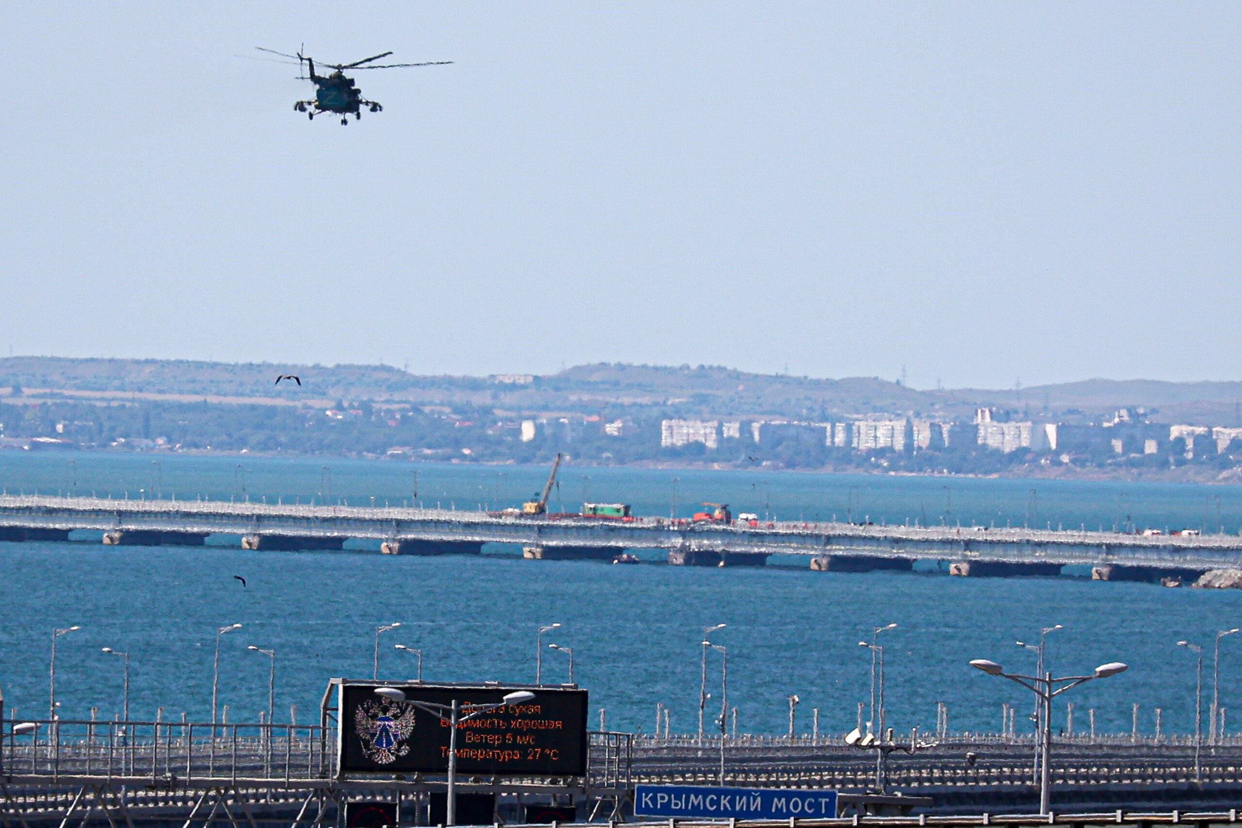 Un helicóptero militar ruso vuela sobre partes dañadas del puente que conecta a Rusia con la península de Crimea sobre el Estrecho de Kerch, el lunes 17 de julio de 2023, no lejos de Kerch, Crimea. (AP Foto)