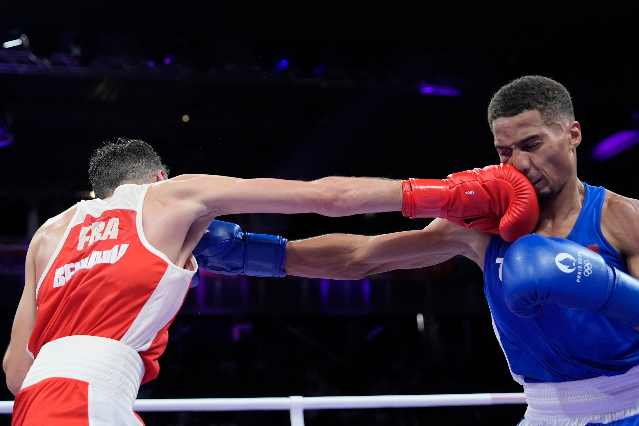 El dominicano Yunior Alcántara, de azul, intercambia golpes con el franc´s Billal Bennama en su combate de semifinales de peso mosca de Juegos Olímpicos, el domingo 4 de agosto de 2024, en Villepinte, Francia. (AP Foto/Ariana Cubillos)