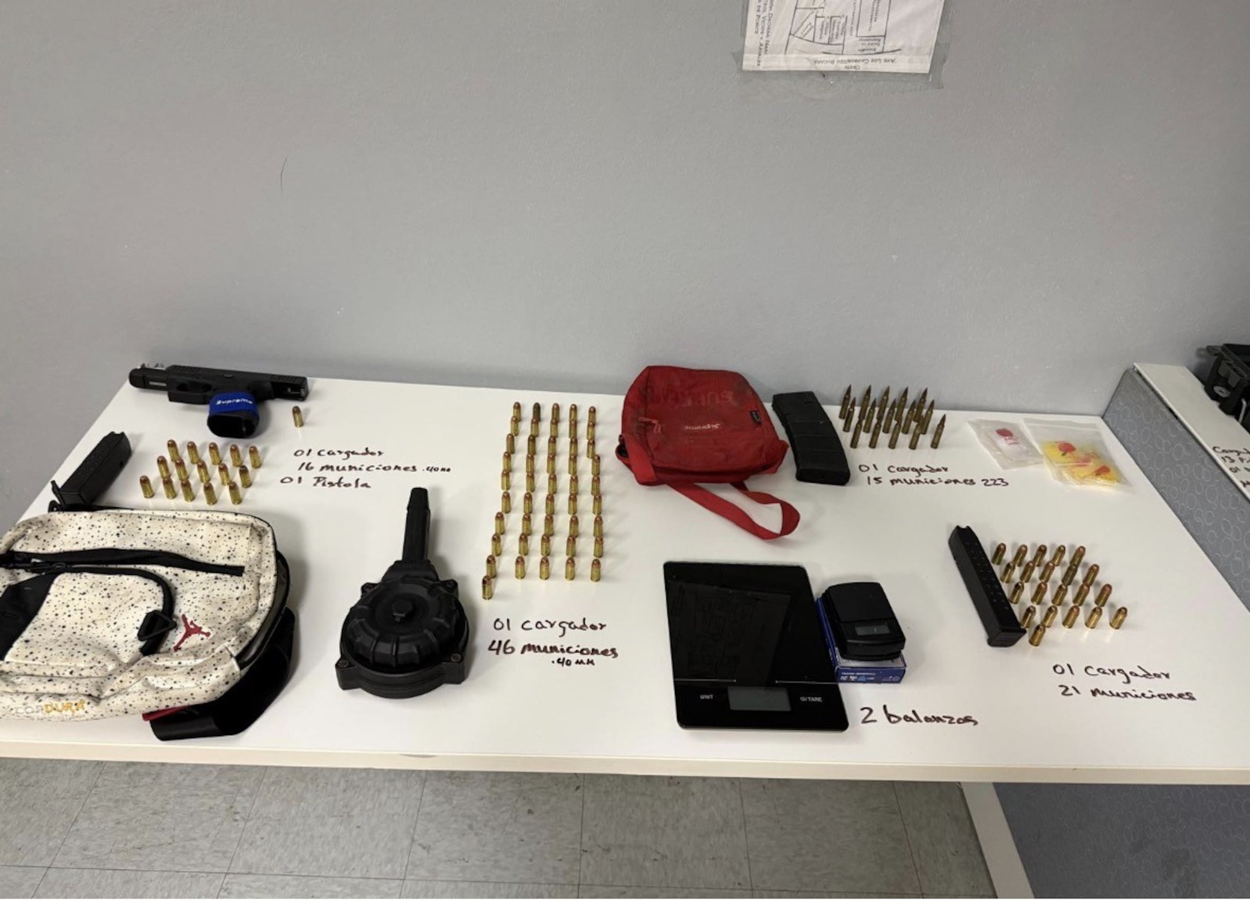 Armas ilegales, piezas, cargadores y balas ocupadas en un solar baldío durante un allanamiento en el barrio Río Chiquito, en Ponce.