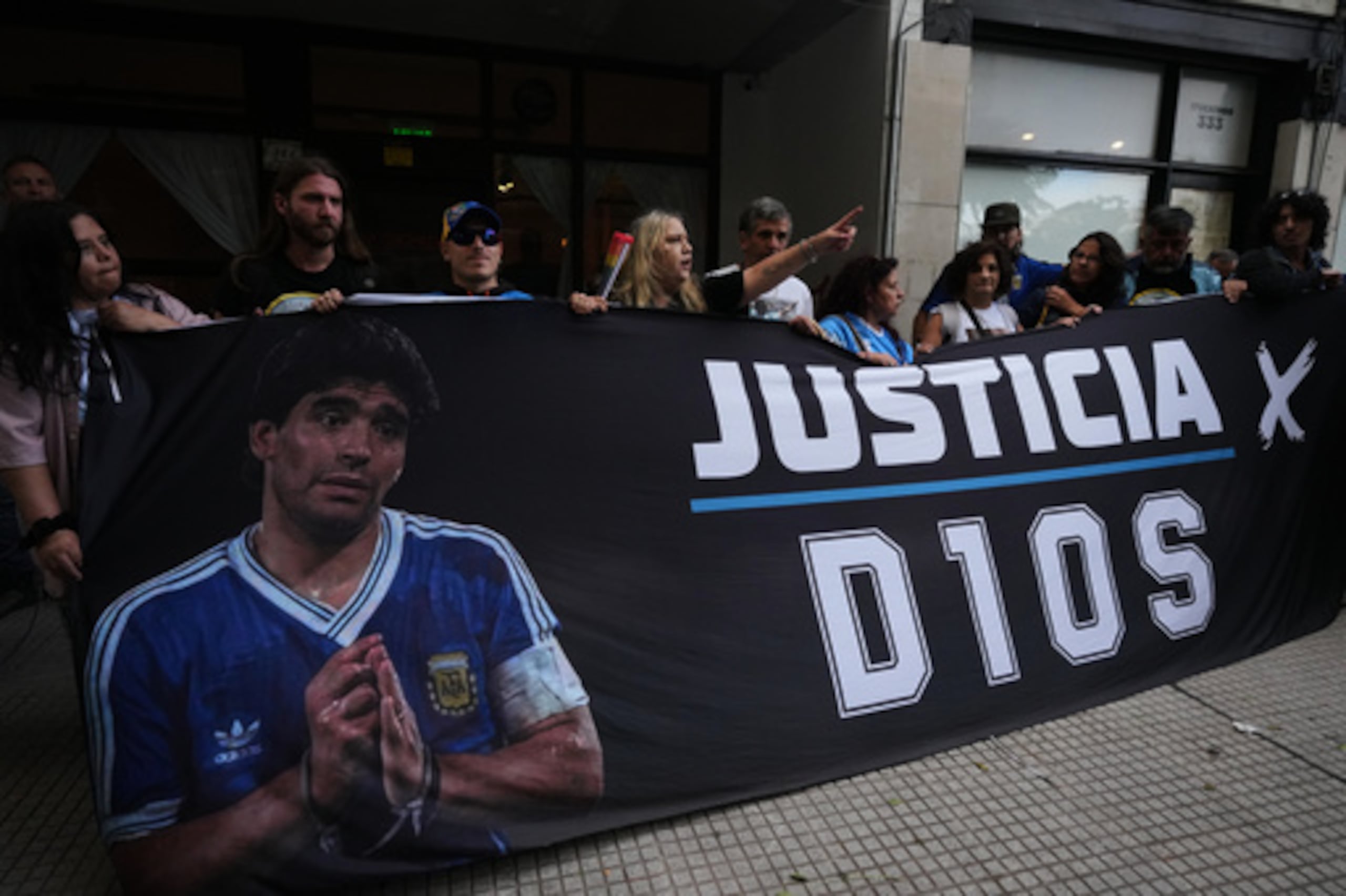 Fanáticos del fallecido astro del fútbol Diego Maradona se paran afuera de la corte en el primer día del juicio a su equipo médico por presunto homicidio por negligencia en San Isidro, Argentina, martes 14 de abril de 2026. (AP Photo/Rodrigo Abd)