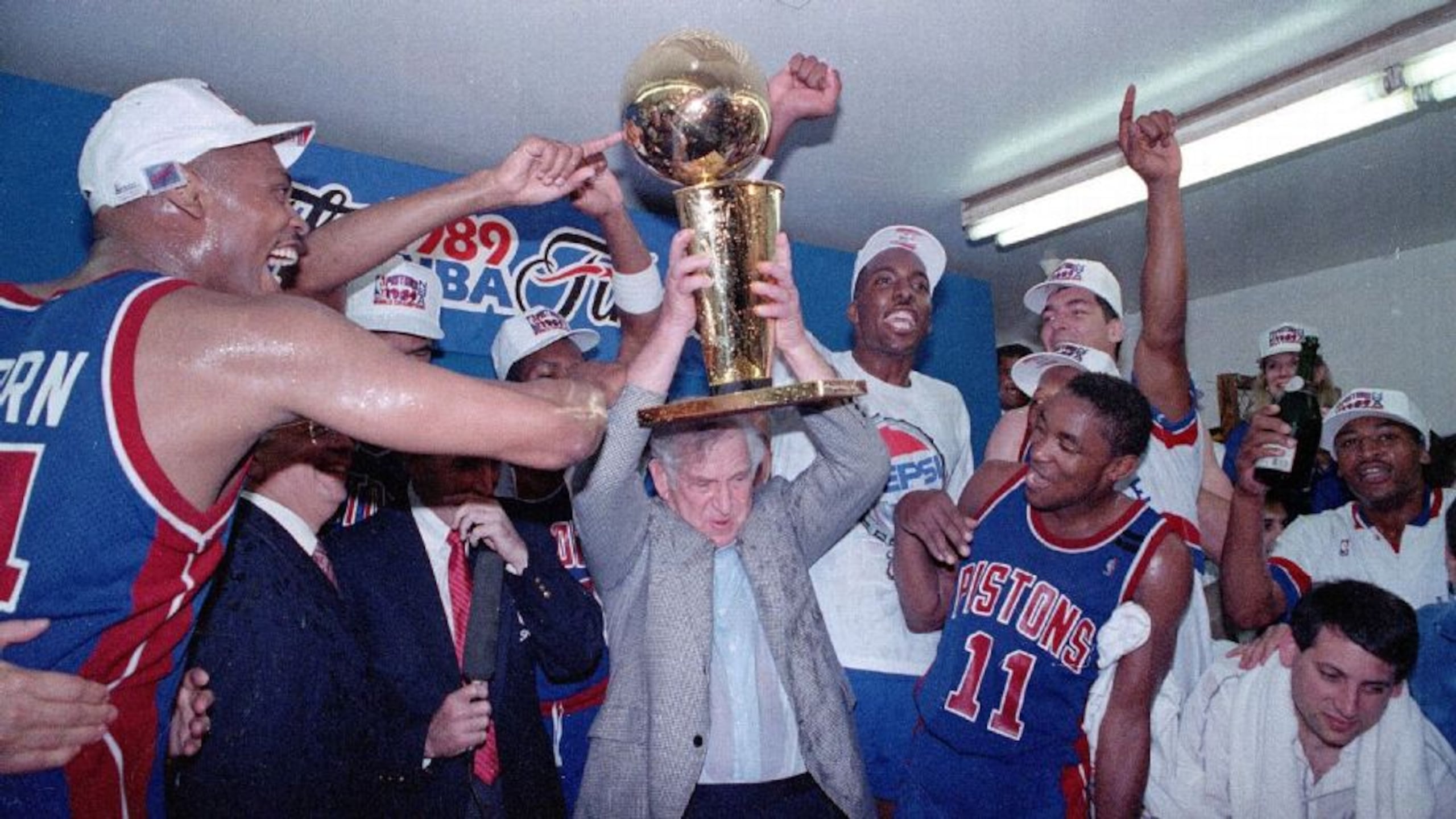 Los Pistons de Detroit celebran el campeonato de 1990 de la NBA. John Salley, derecha con gorra, aparece festejando al lado del Larry O'Brien. (Doug Pizac/AP Photo)