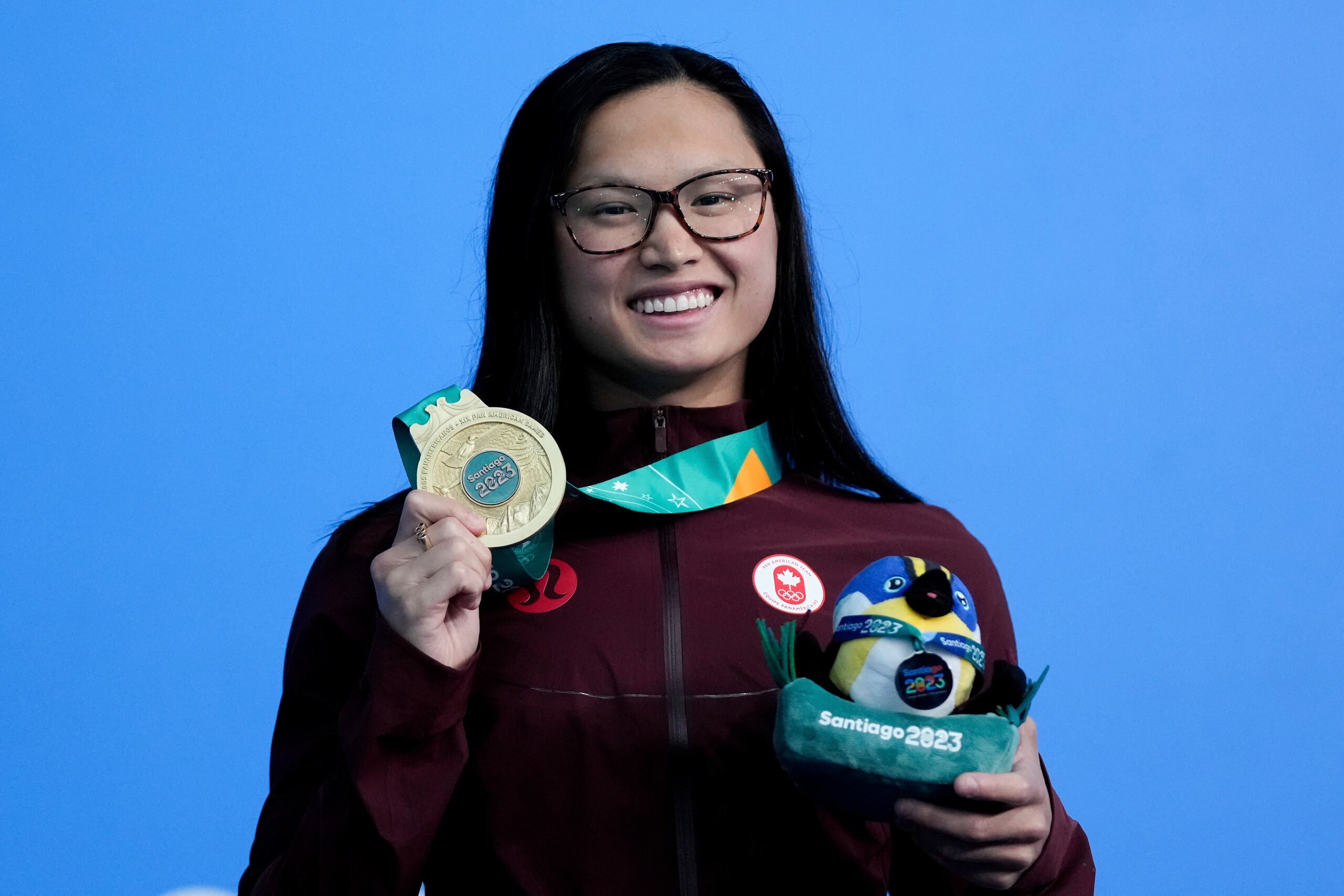La canadiense Maggie McNeil posa con su medalla de oro tras ganar los 100 metros mariposa en la natación de los Juegos Panamericanos en Santiago, Chile, el domingo 22 de octubre de 2023. (AP Foto/Silvia Izquierdo)