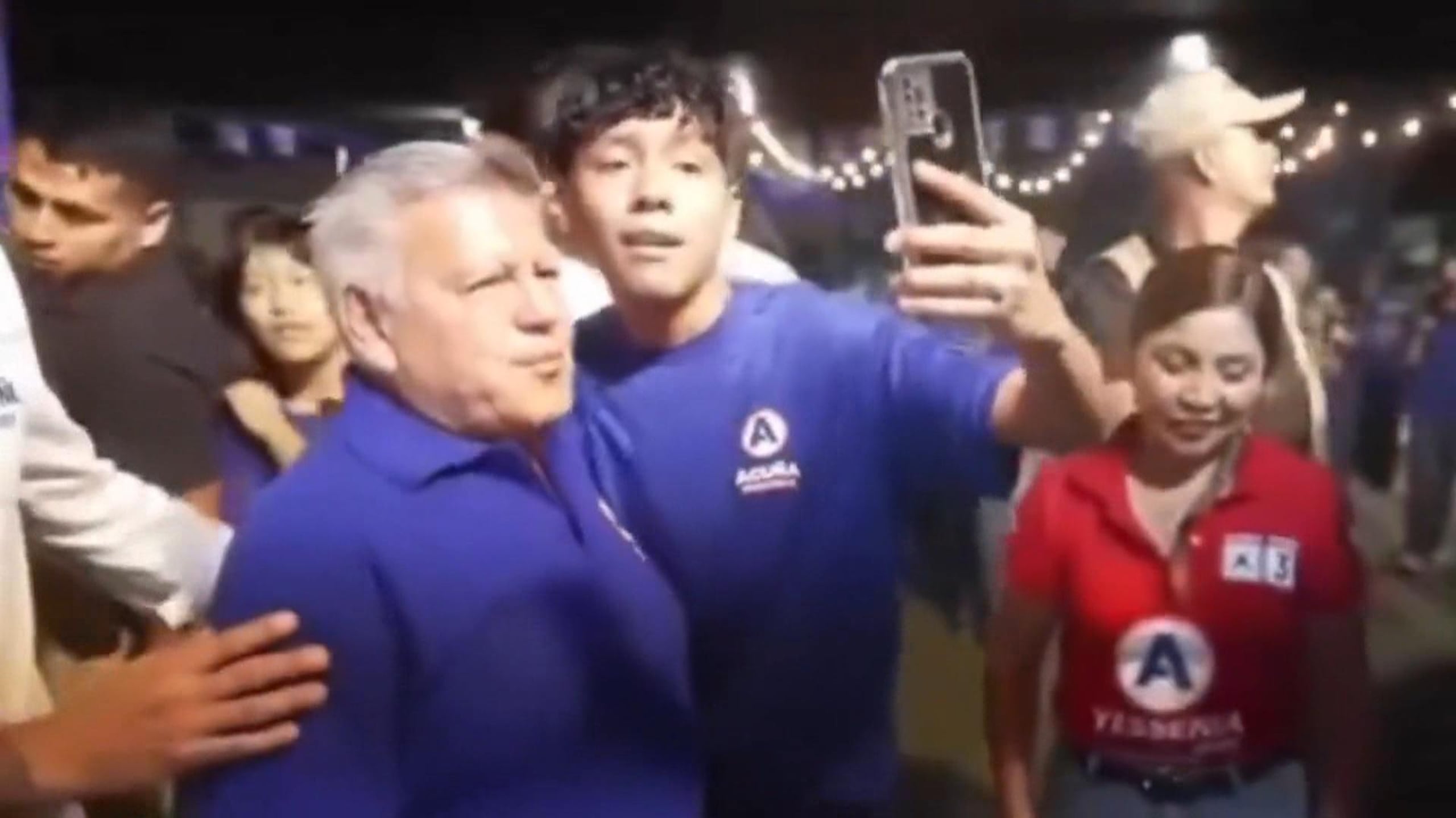 Captura de video tomada a través de rastreo de redes del empresario derechista y candidato presidencial en Perú César Acuña (i) junto a un joven que le rompió un huevo contra su cabeza durante un acto electoral.