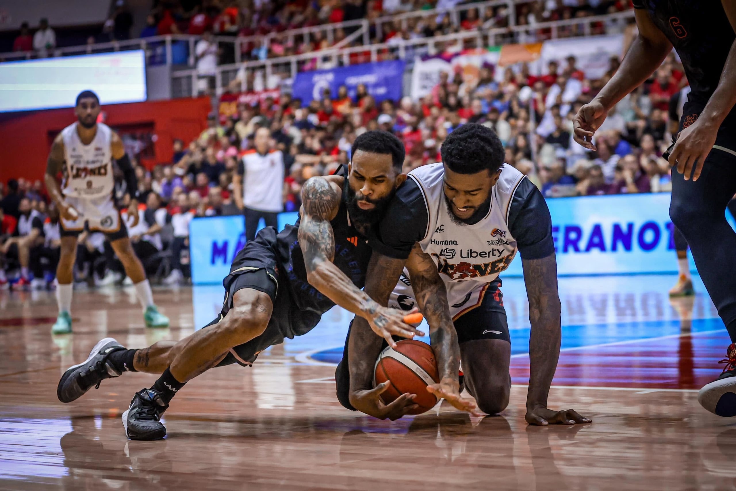Walter Hodge Jr, de los Cangrejeros, y Jordan Bell, de los Leones, se pelean por el balón durante el partido de reto en Ponce.